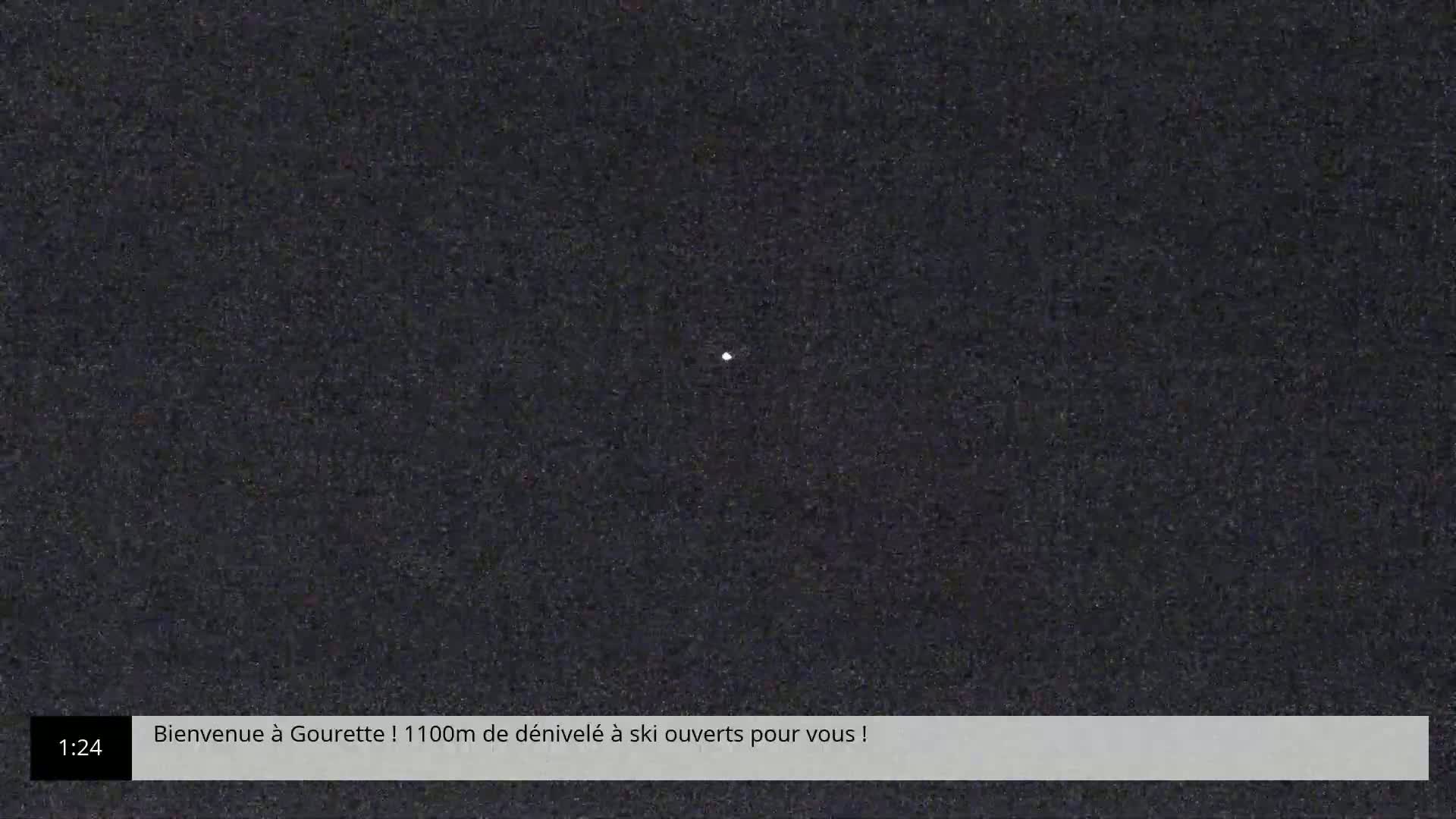 A single, small, bright light is visible against a dark, grainy background at night.