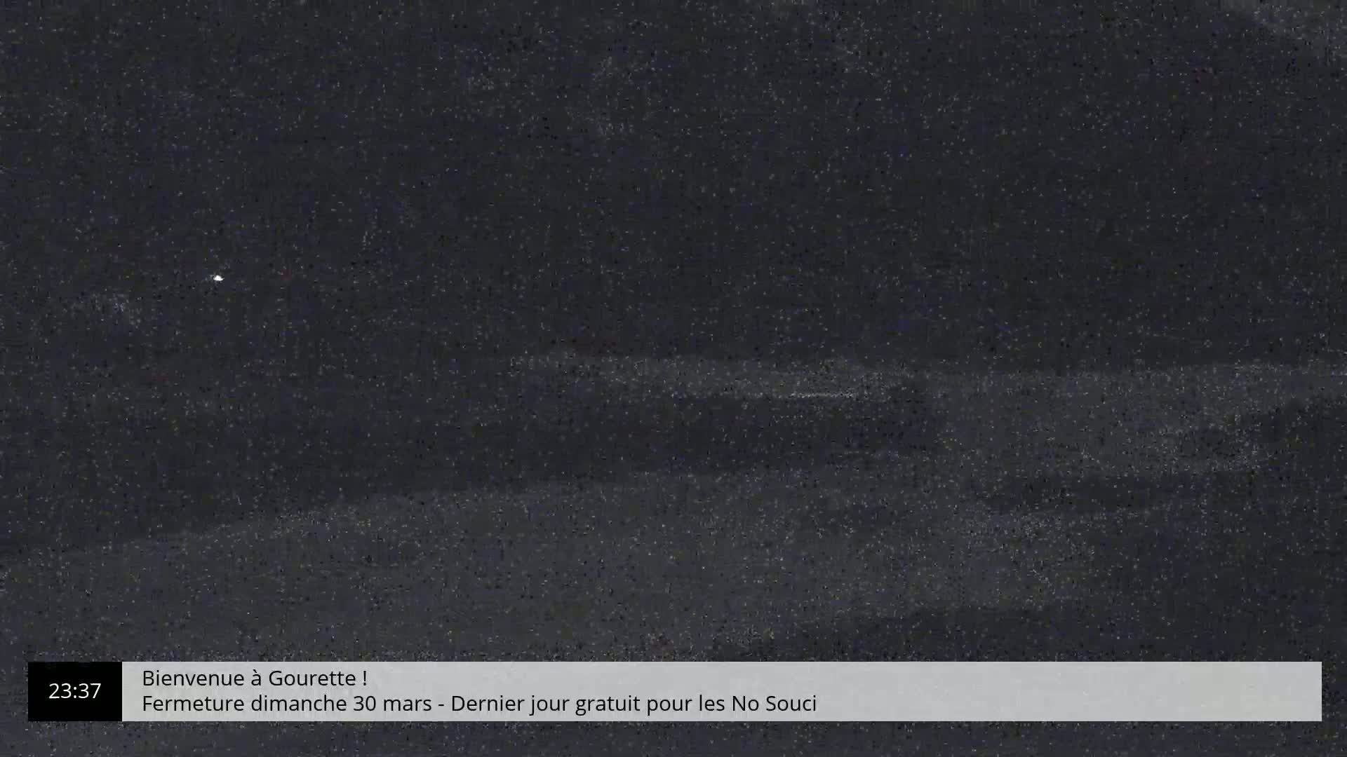 A dark, grainy nighttime image shows a mostly indistinct, dark landscape.