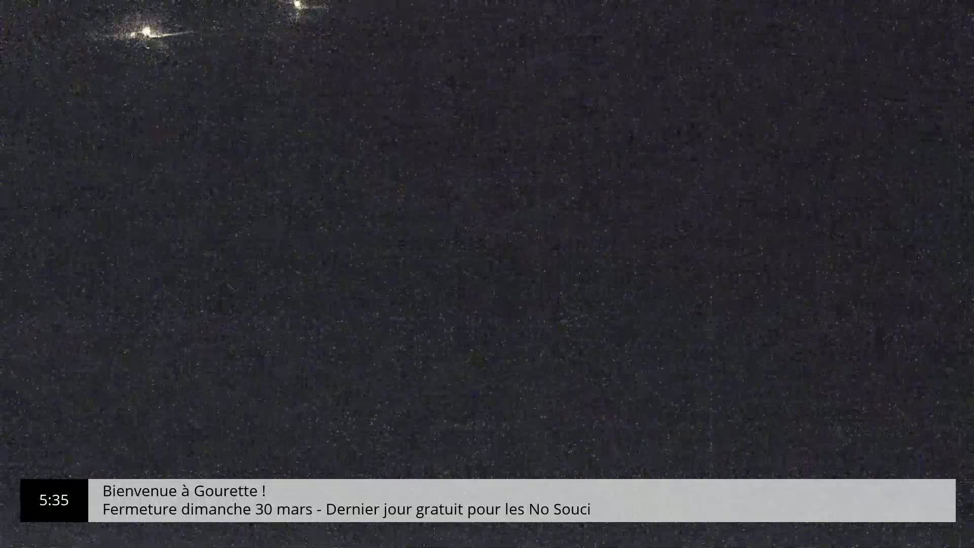 A dark, grainy nighttime image shows a few distant lights.