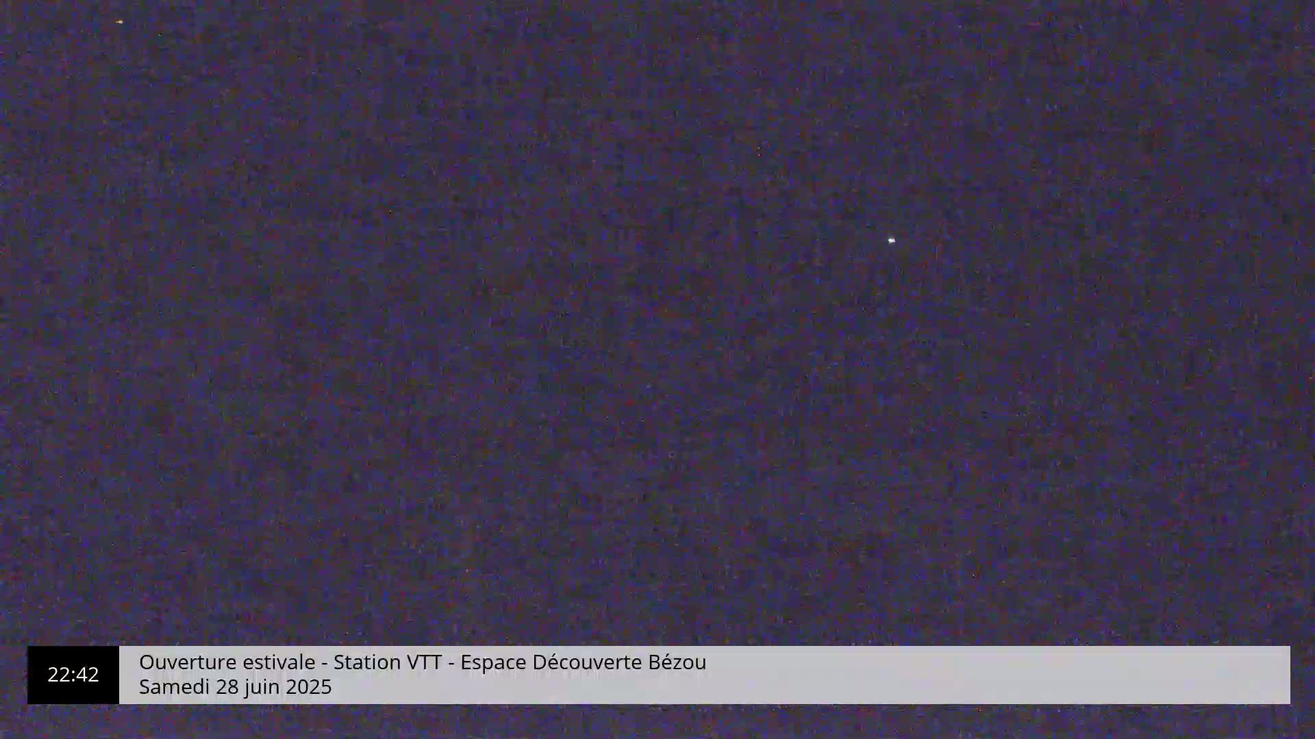 A single, bright point of light is visible against a dark, nighttime sky.