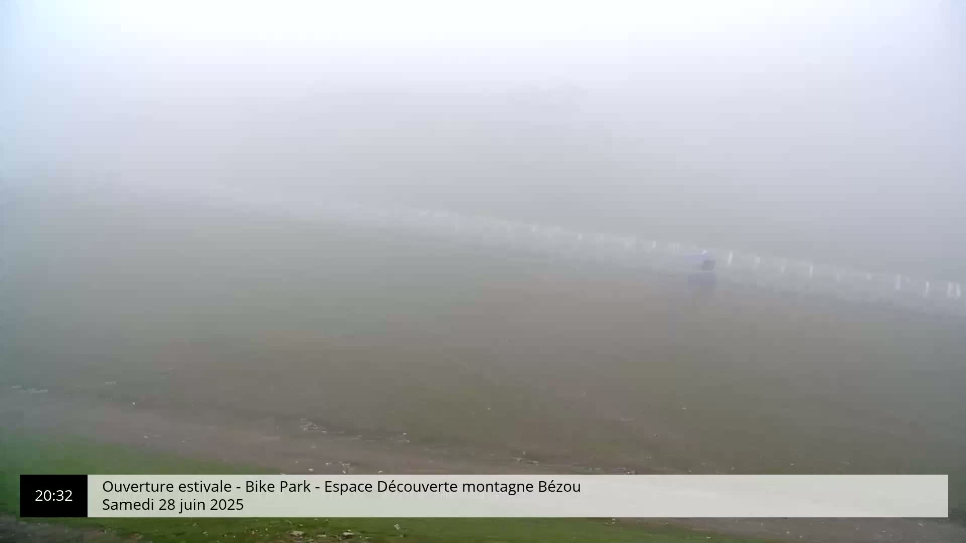 A foggy landscape shows a long, indistinct line of objects in the midground, possibly markers or posts, with a small figure visible near them.