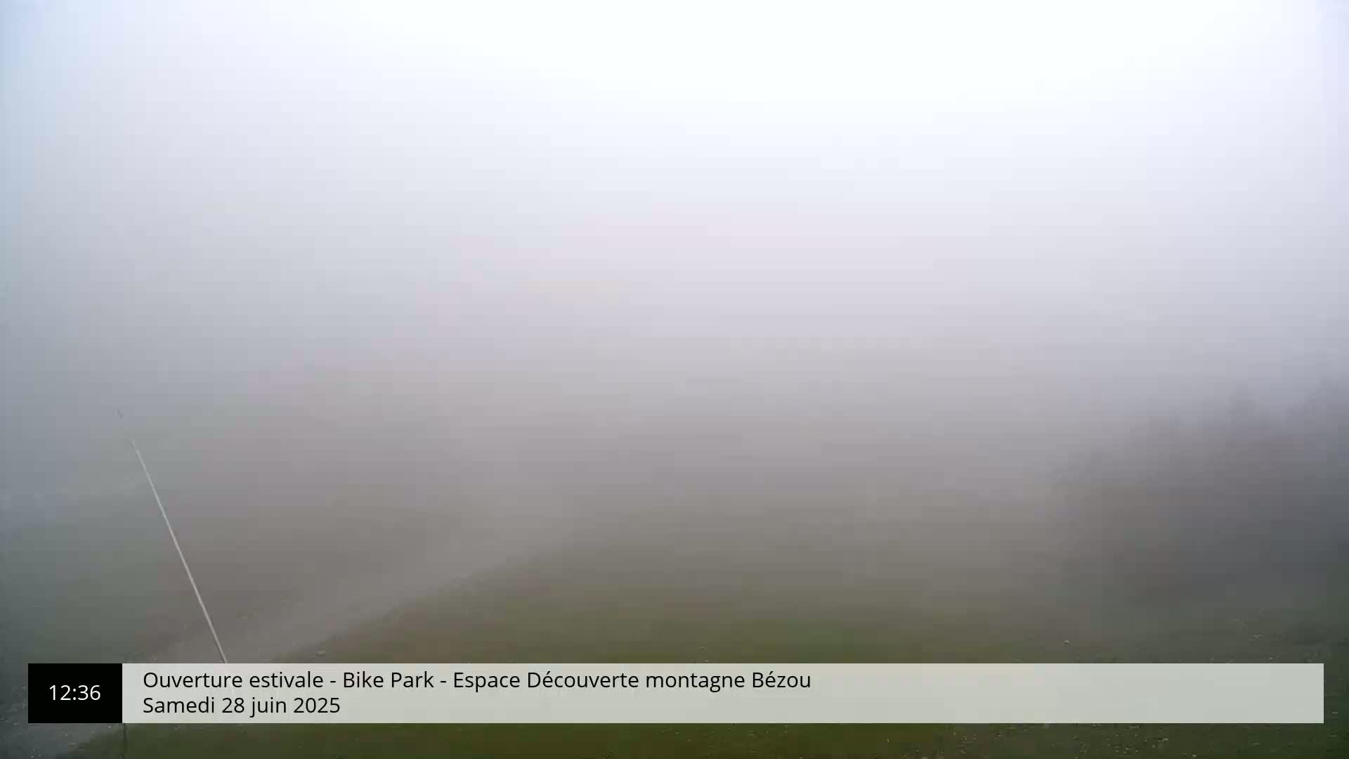 A foggy, outdoor scene shows a mostly obscured landscape with a tall pole extending from the bottom left corner.