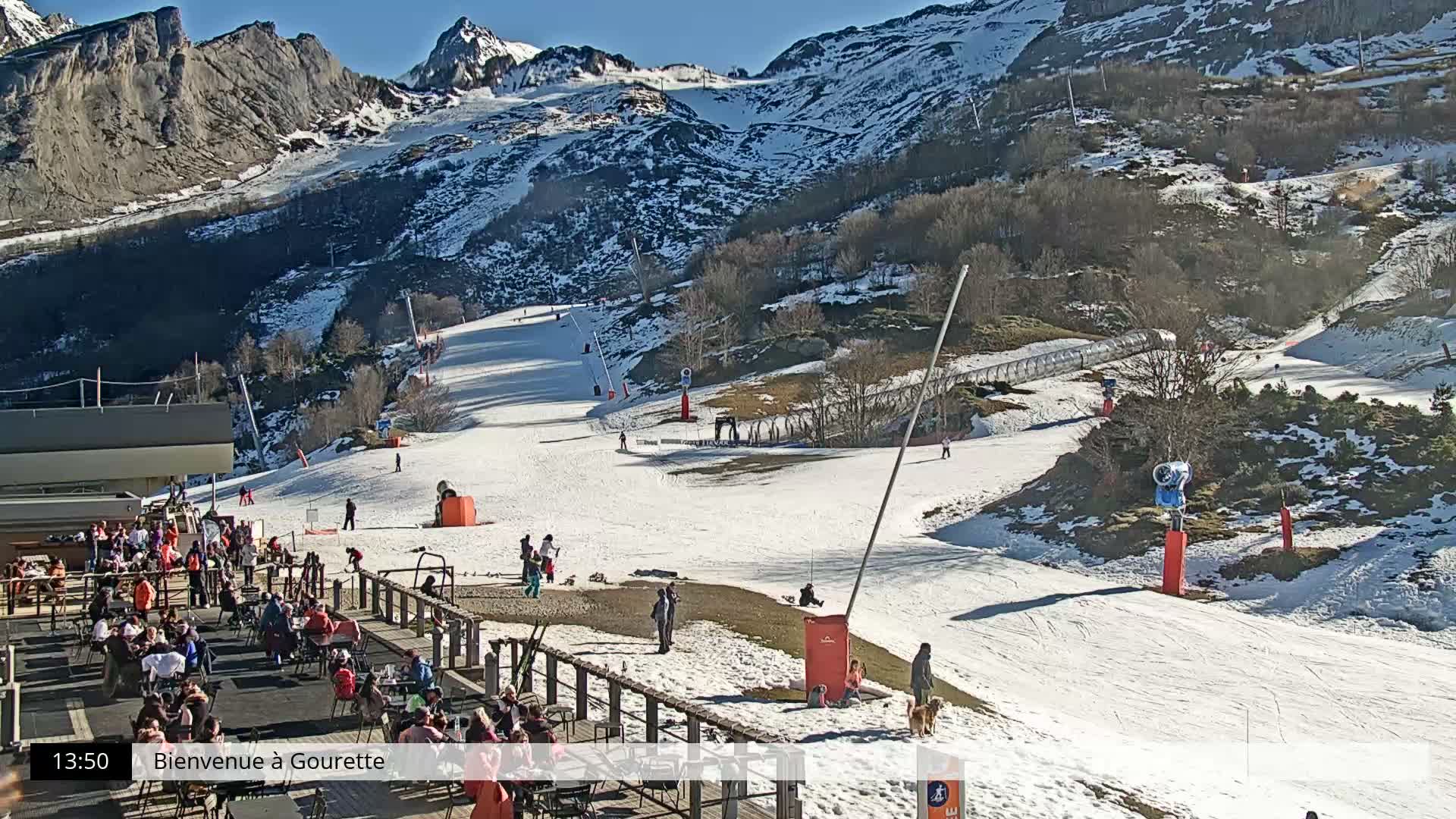 A wide view of a snow-covered mountain ski resort reveals numerous ski lifts, snow-laden trees, and pristine slopes under an overcast winter sky.