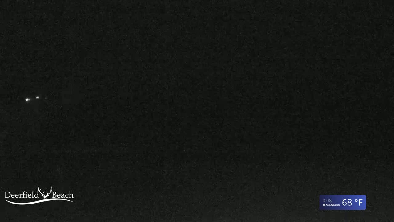A nighttime image shows a dark, mostly featureless scene with three small, bright lights in the distance and a temperature of 68°F.