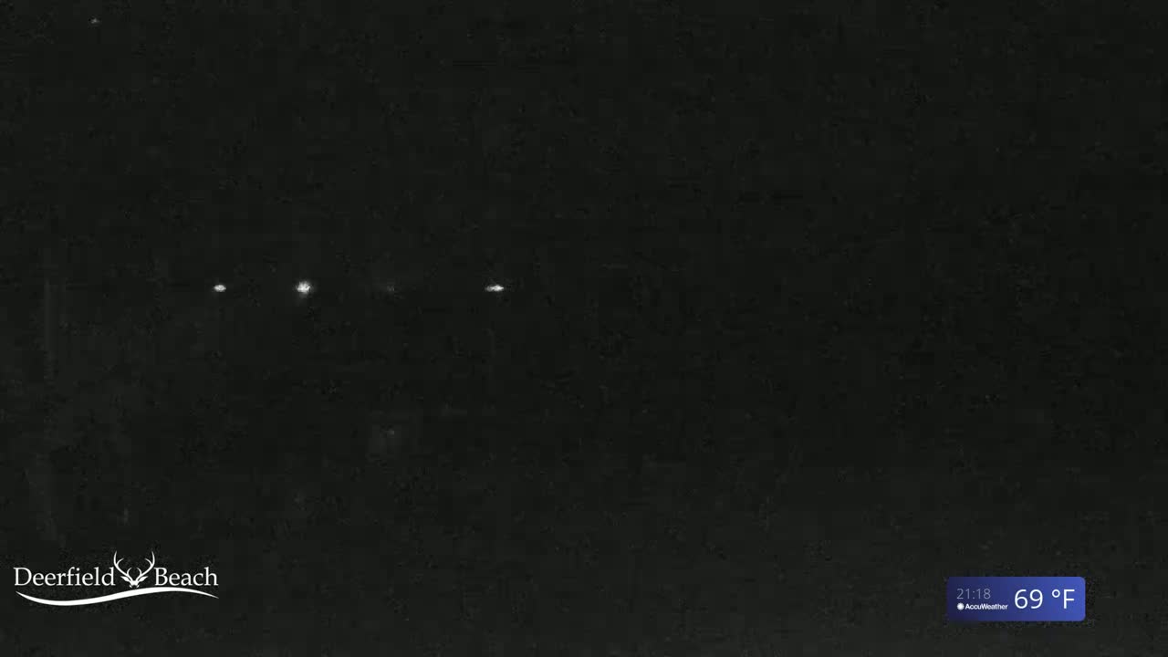 A dark, nighttime scene shows several faint lights in the distance under a clear sky with a temperature of 69°F.