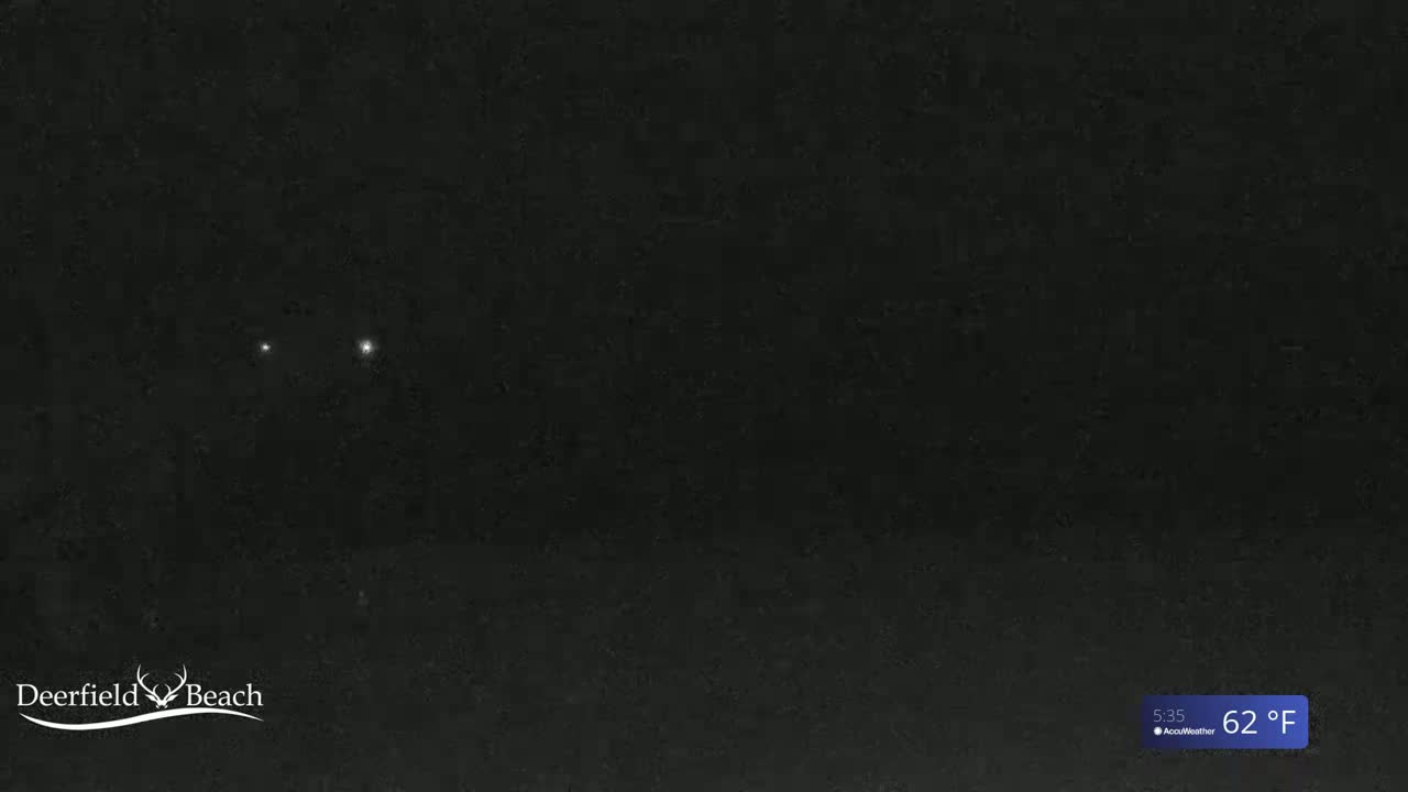A mostly dark image shows two bright lights in the night sky at 62°F.