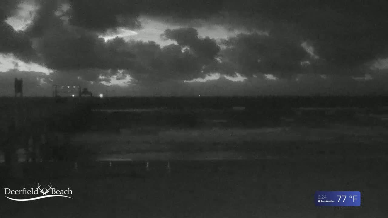A dark, overcast sky hangs over a flat, dark landscape at night.