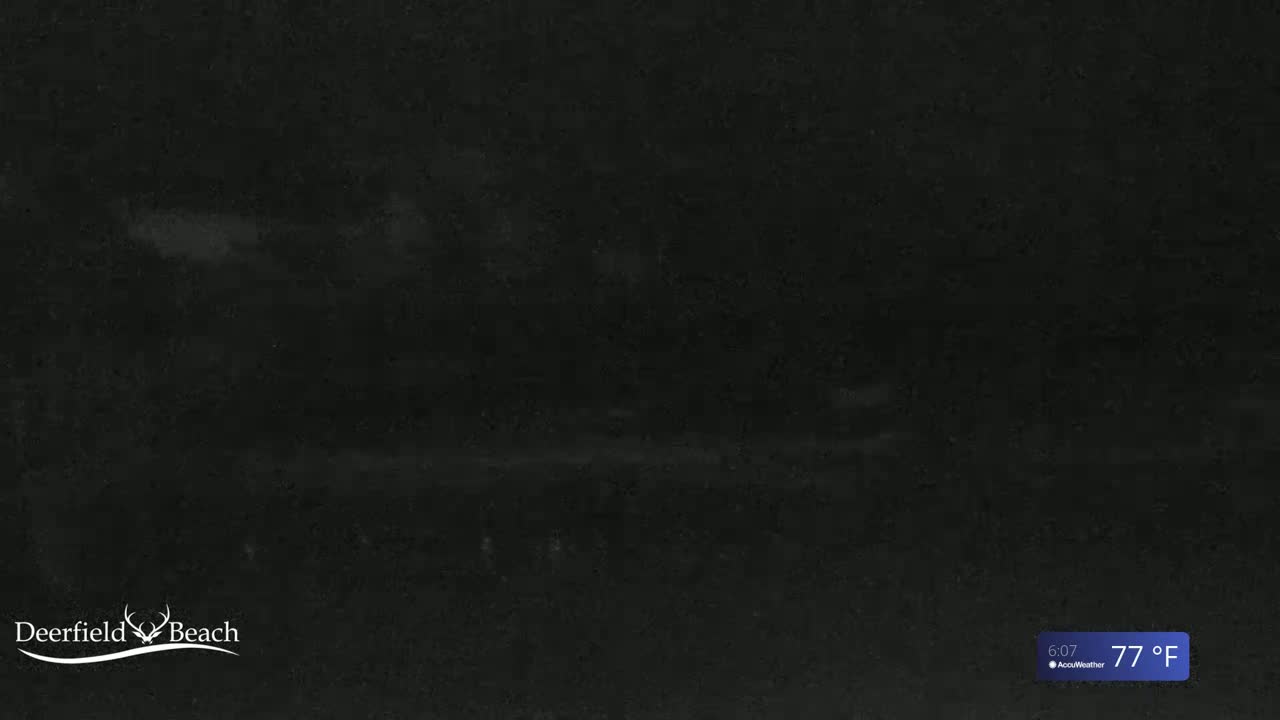 A dark, nighttime scene with an overcast sky and a temperature of 77°F.