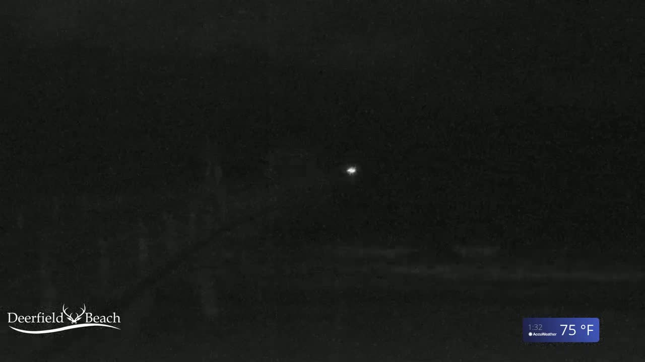 A nighttime outdoor scene shows a dimly lit area with a single bright light in the distance, under a 75°F sky.