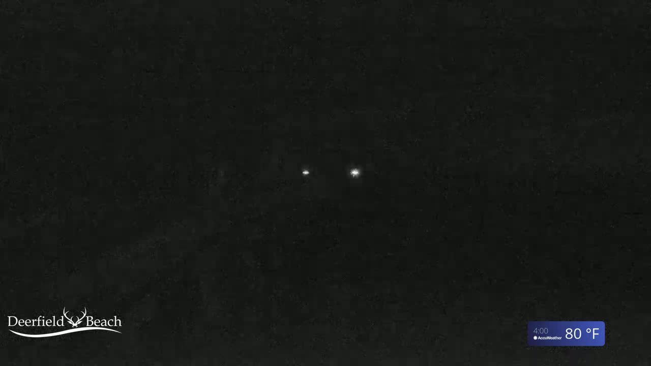 Two small, bright lights are visible in the dark, nighttime scene at 80°F.