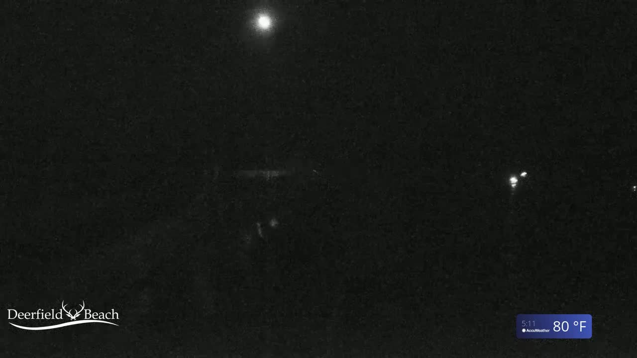 A nighttime, low-light view of a dark scene under a bright moon, with a temperature of 80°F.