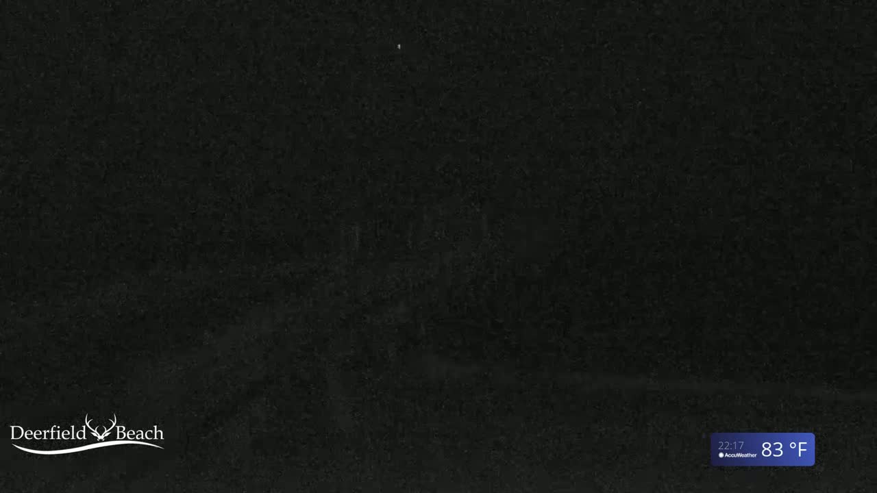 A nighttime image shows a dark, possibly obscured view of an outdoor scene under a clear sky, with a temperature of 83 degrees Fahrenheit.