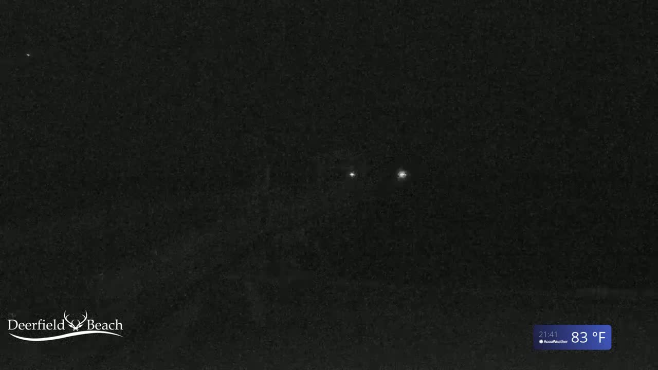 A nighttime image shows two small, bright lights in the distance against a dark, grainy background, with an 83°F temperature shown at the bottom right.