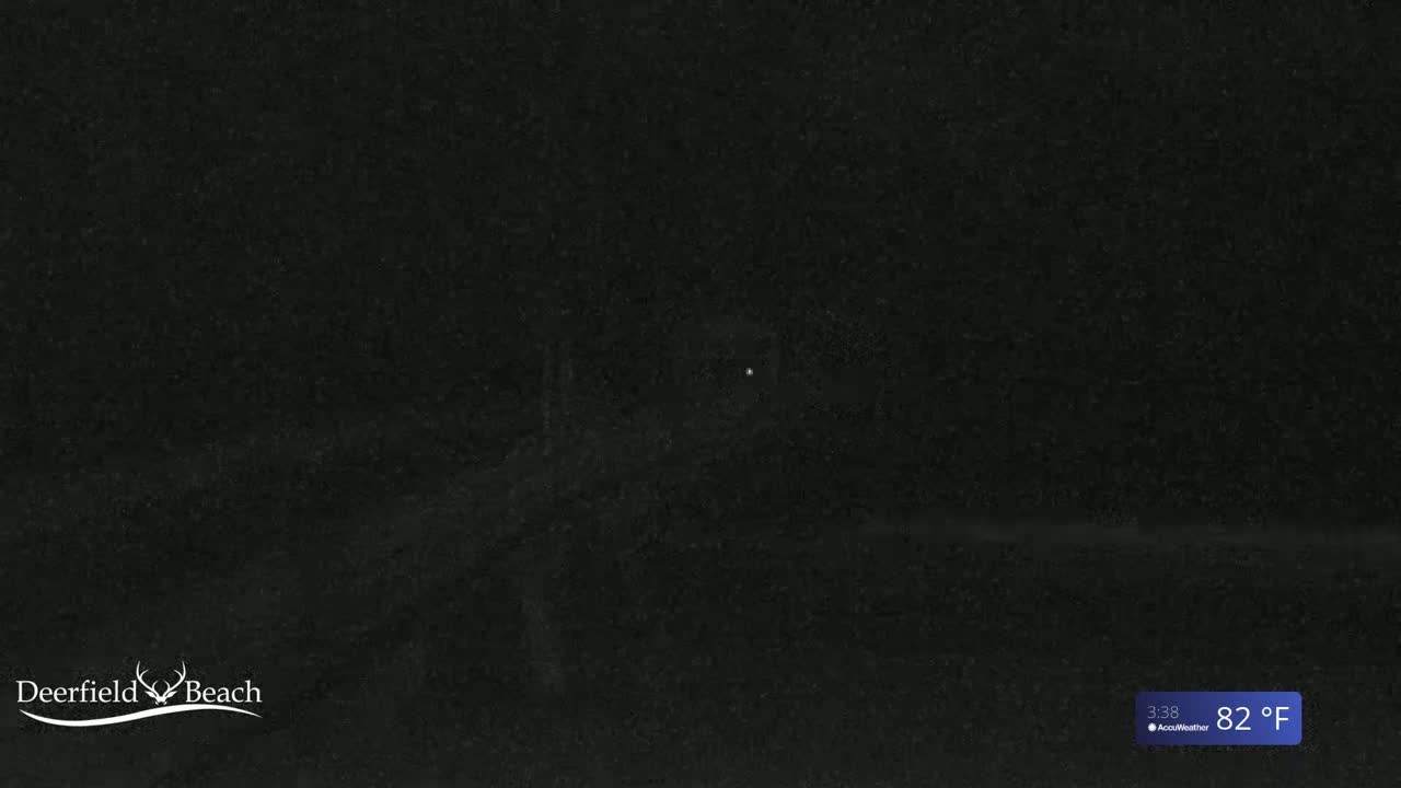 A dark, nighttime outdoor scene shows a mostly obscured view of a beach area under a clear sky at 82°F.