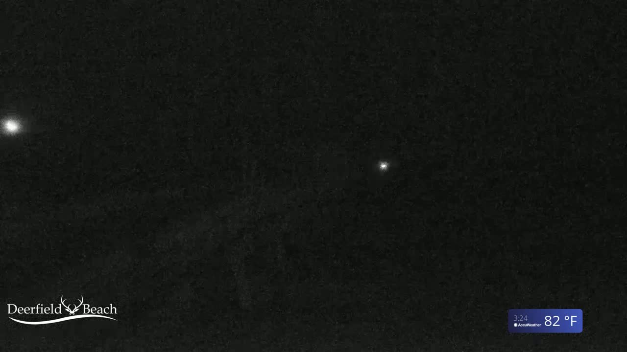 A nighttime, dark image shows two bright lights in the distance under an 82°F sky.