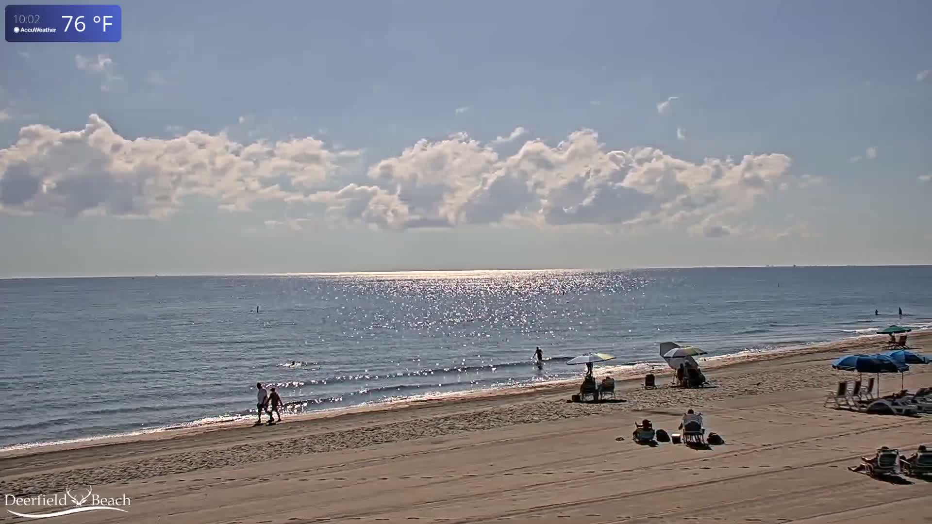 A dark night scene over calm water with clear skies features a bright light source on the left and a larger, more prominent light source in the upper right, both reflecting on the water's surface.