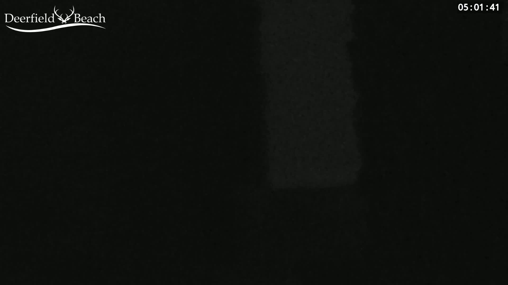 A mostly dark image shows a very dimly lit scene, possibly at night.