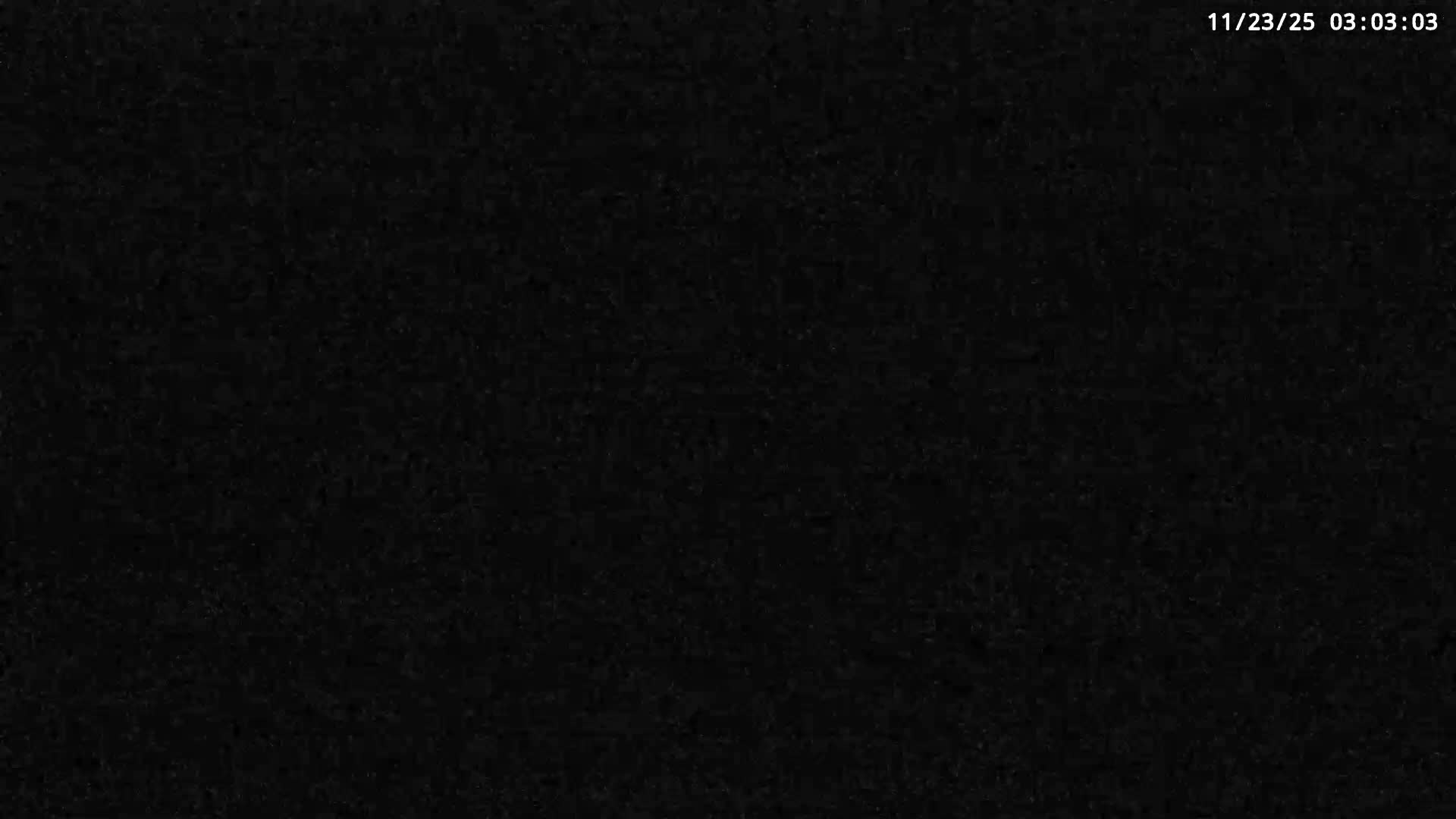 The image is almost entirely black with faint digital noise, making it impossible to discern any identifiable objects, scene, or weather conditions.