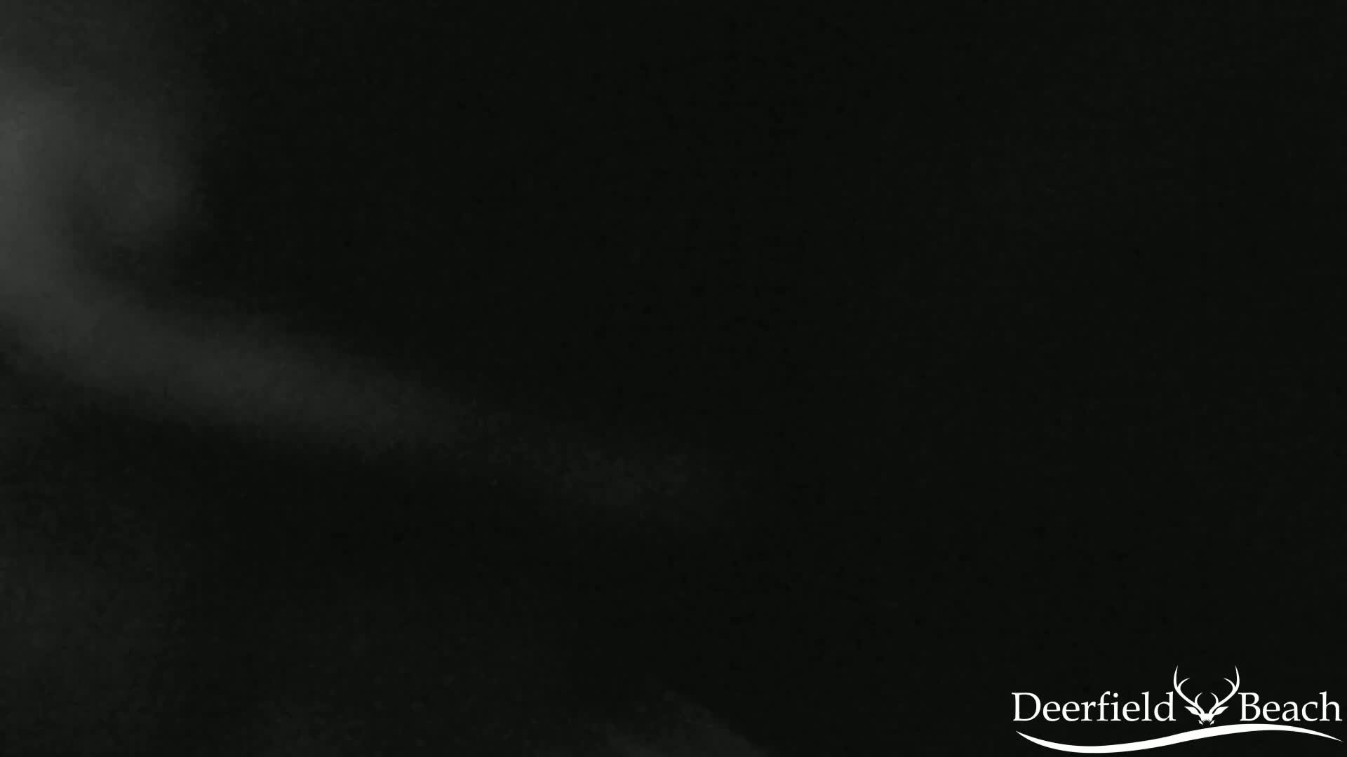 A dark, blurry image shows a faint, diagonal streak of light against a predominantly black background.