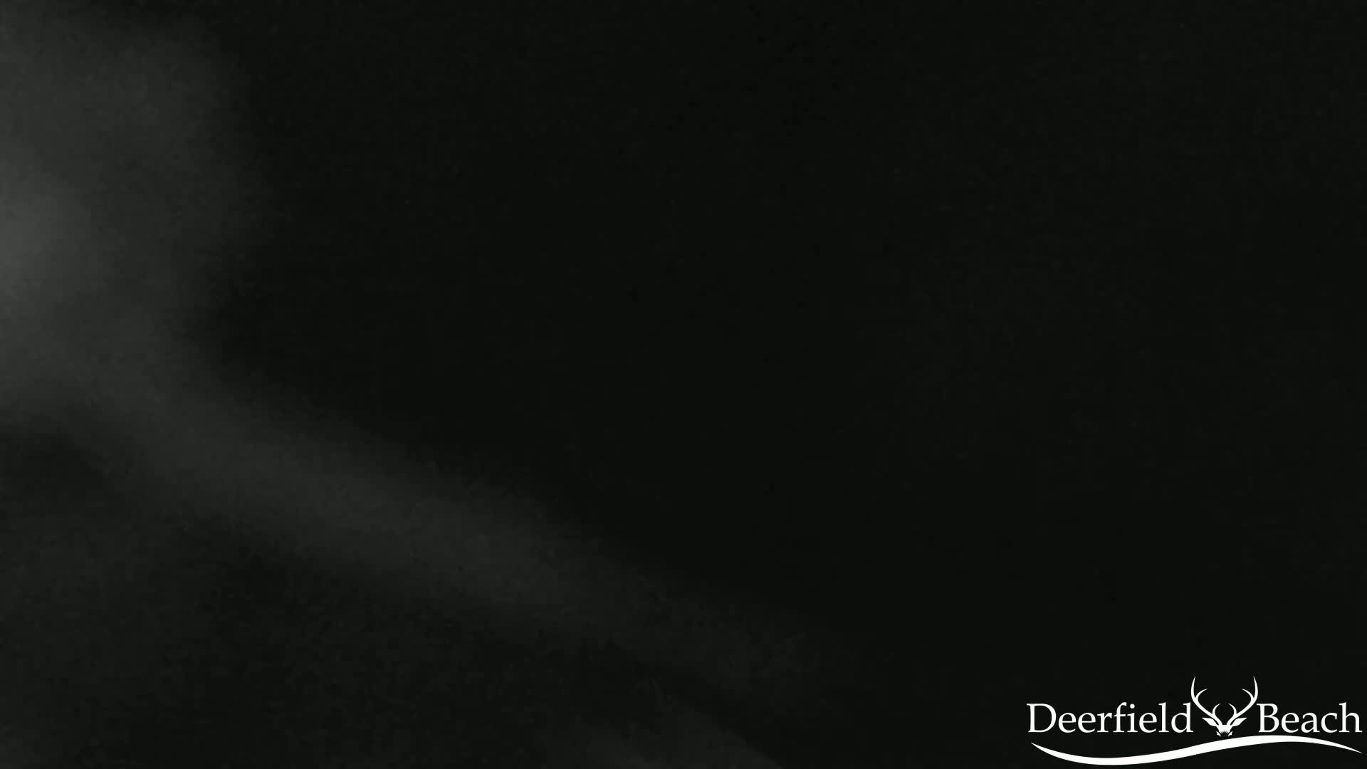 A mostly dark image shows a hazy, light gray beam or glow emanating from the bottom left corner.