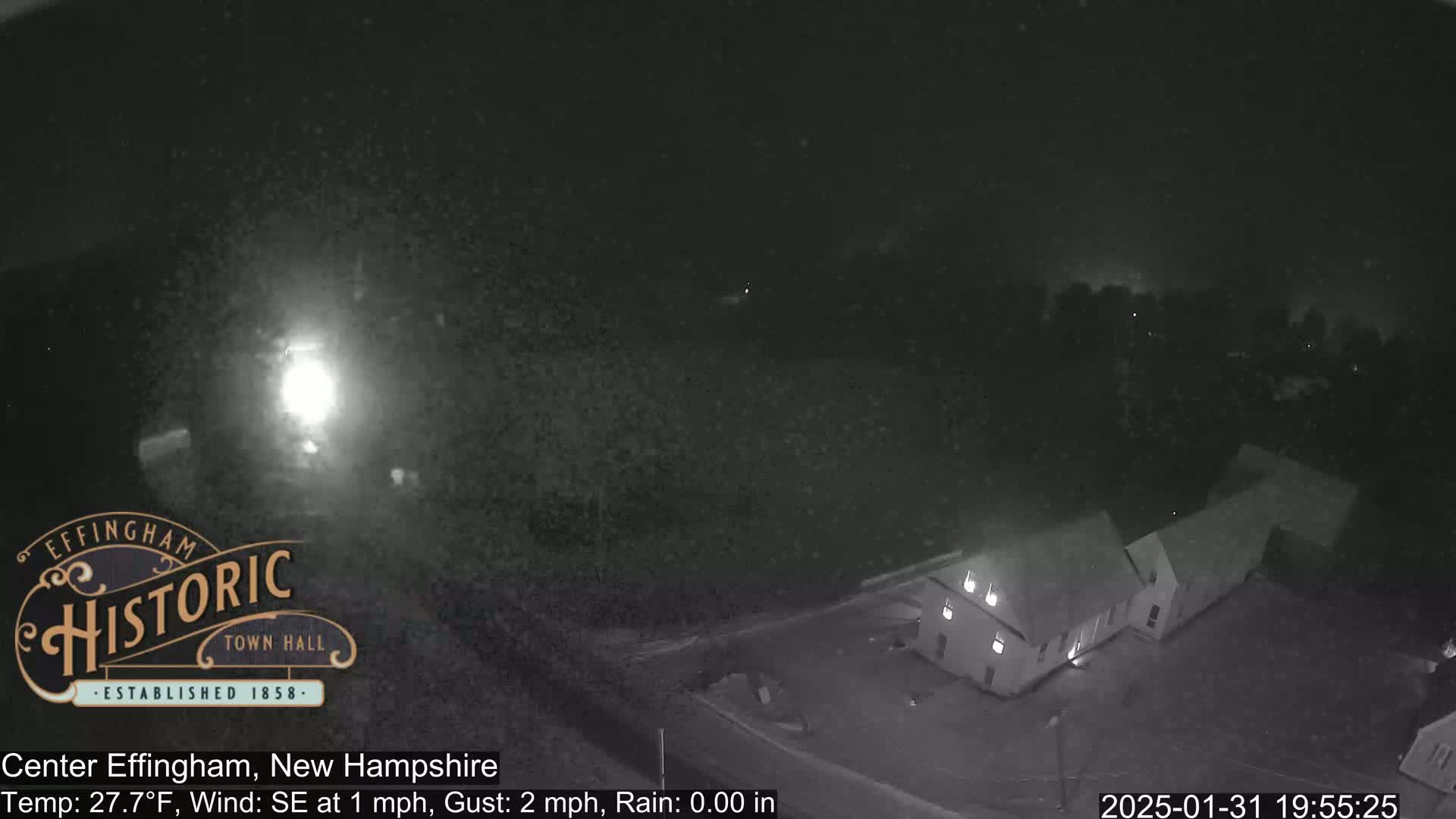 A nighttime, high-angle, low-light view of a building complex with a clear sky and a southeast wind of 1 mph, with gusts up to 2 mph and no rain.