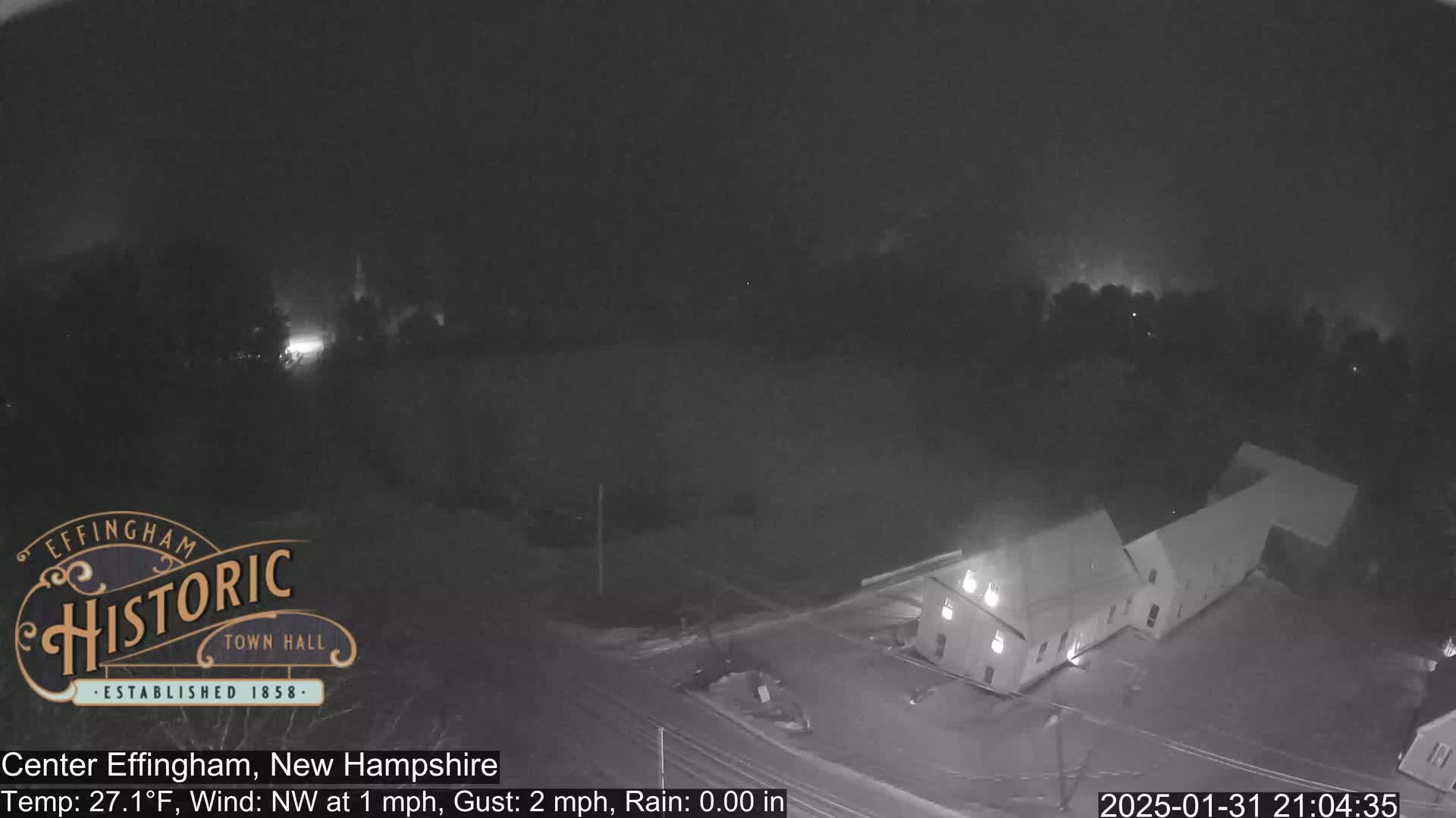 A nighttime, low-light view of a building and surrounding area with a northwest wind at 1 mph and a gust of 2 mph, and no rain.