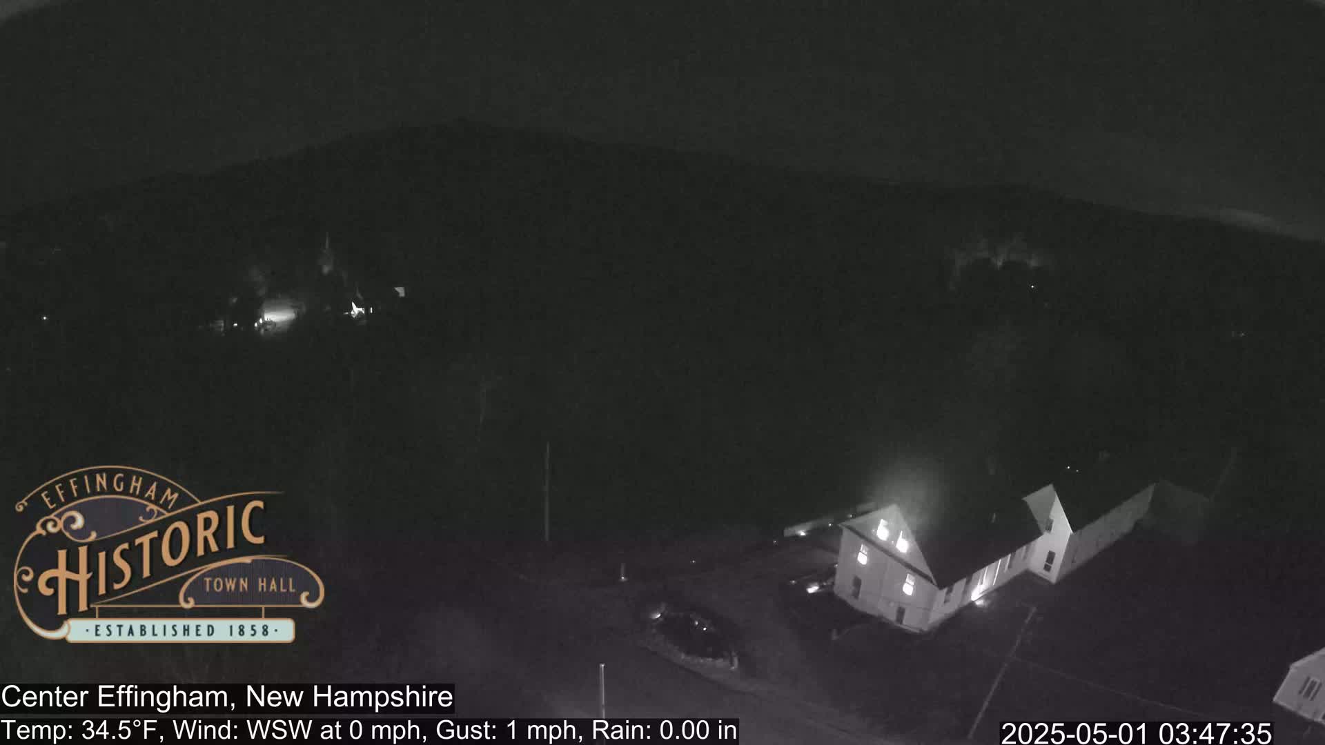 A nighttime aerial view shows a building and surrounding area with calm weather conditions.