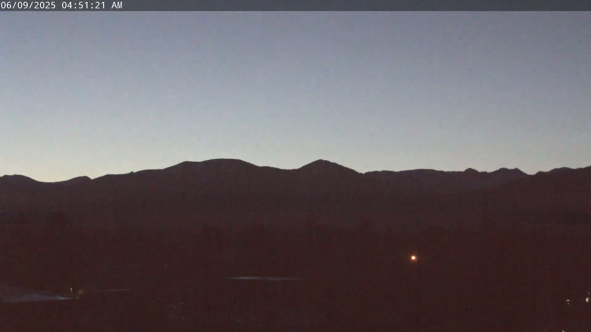 A dark, silhouetted mountain range is visible against a twilight sky.