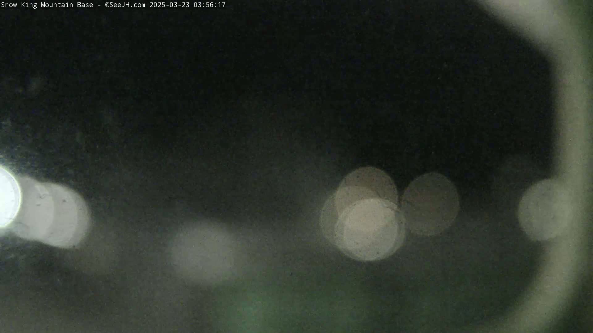 A nighttime, blurry image shows out-of-focus lights against a dark background.