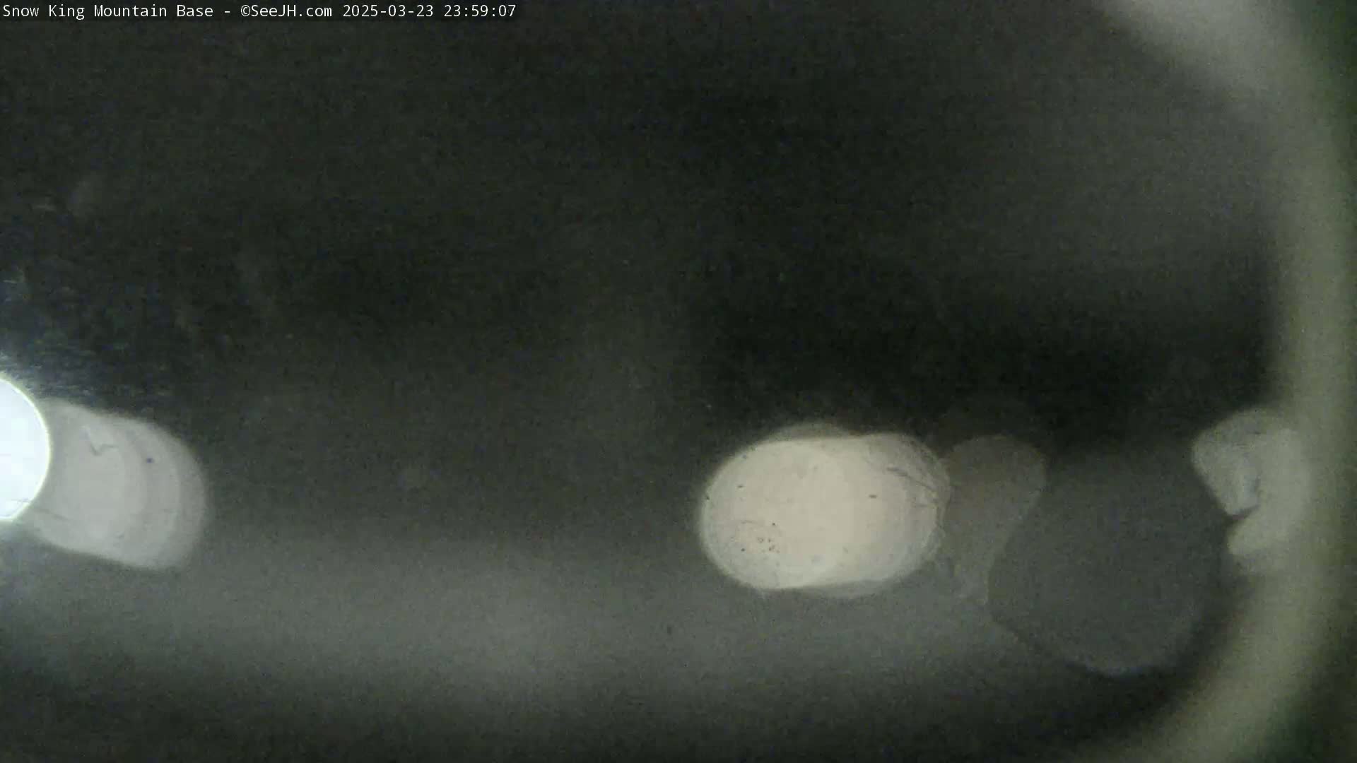 A blurry nighttime image shows out-of-focus lights in the dark.