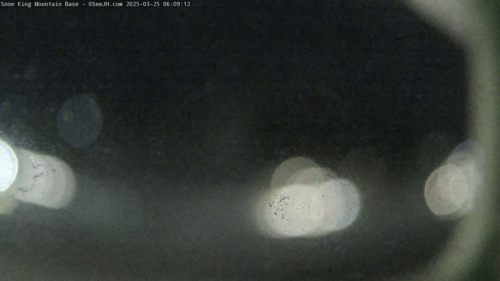 A blurry, nighttime image shows out-of-focus lights in the distance.