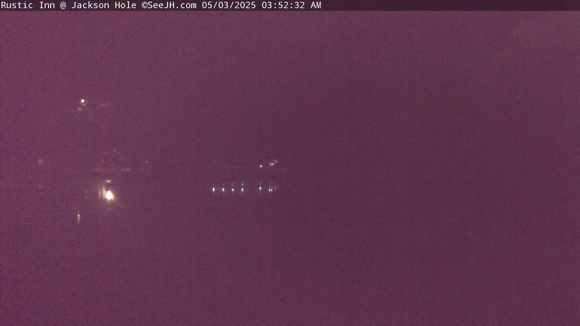 A nighttime, hazy view shows a few distant lights possibly from buildings or vehicles.