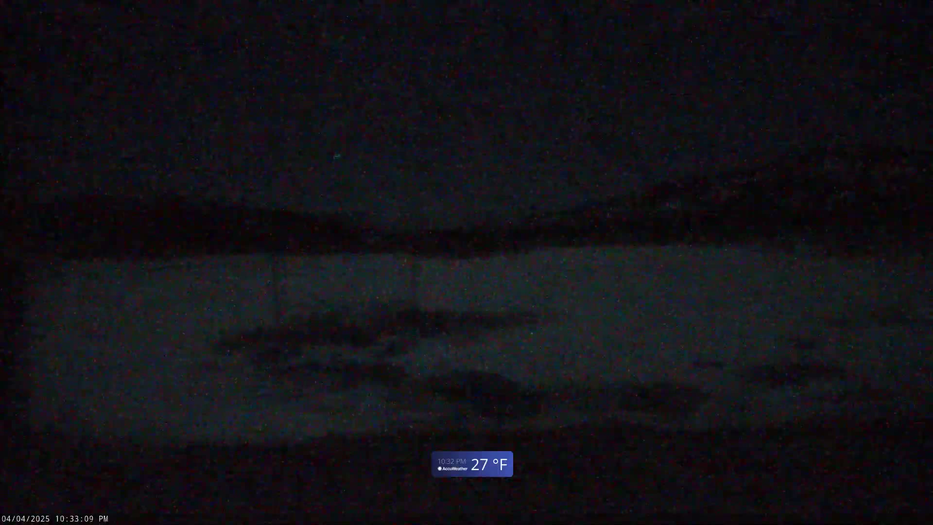 A dark, nighttime scene shows a body of water under a mostly clear sky, with the temperature reading 27°F.