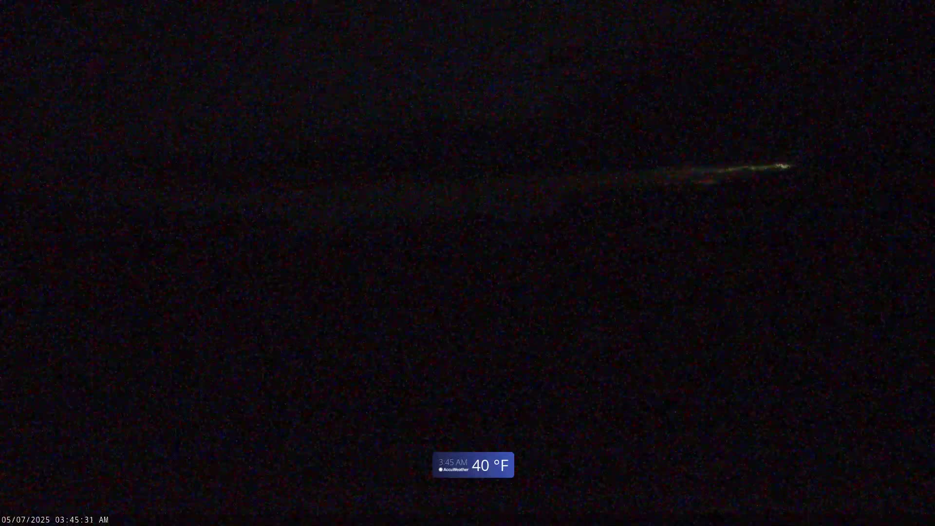 A long, faint streak of light is visible in the dark night sky, with a temperature of 40°F.