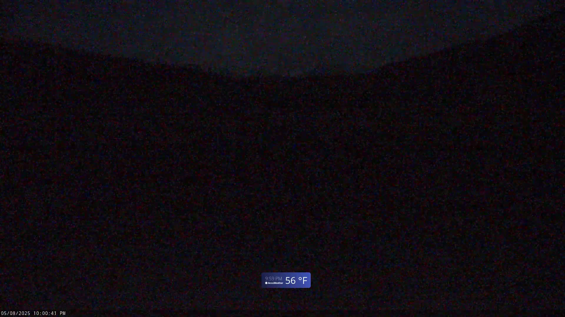 A dark, nighttime view of a hilly landscape under a clear sky, with a temperature of 56 degrees Fahrenheit.