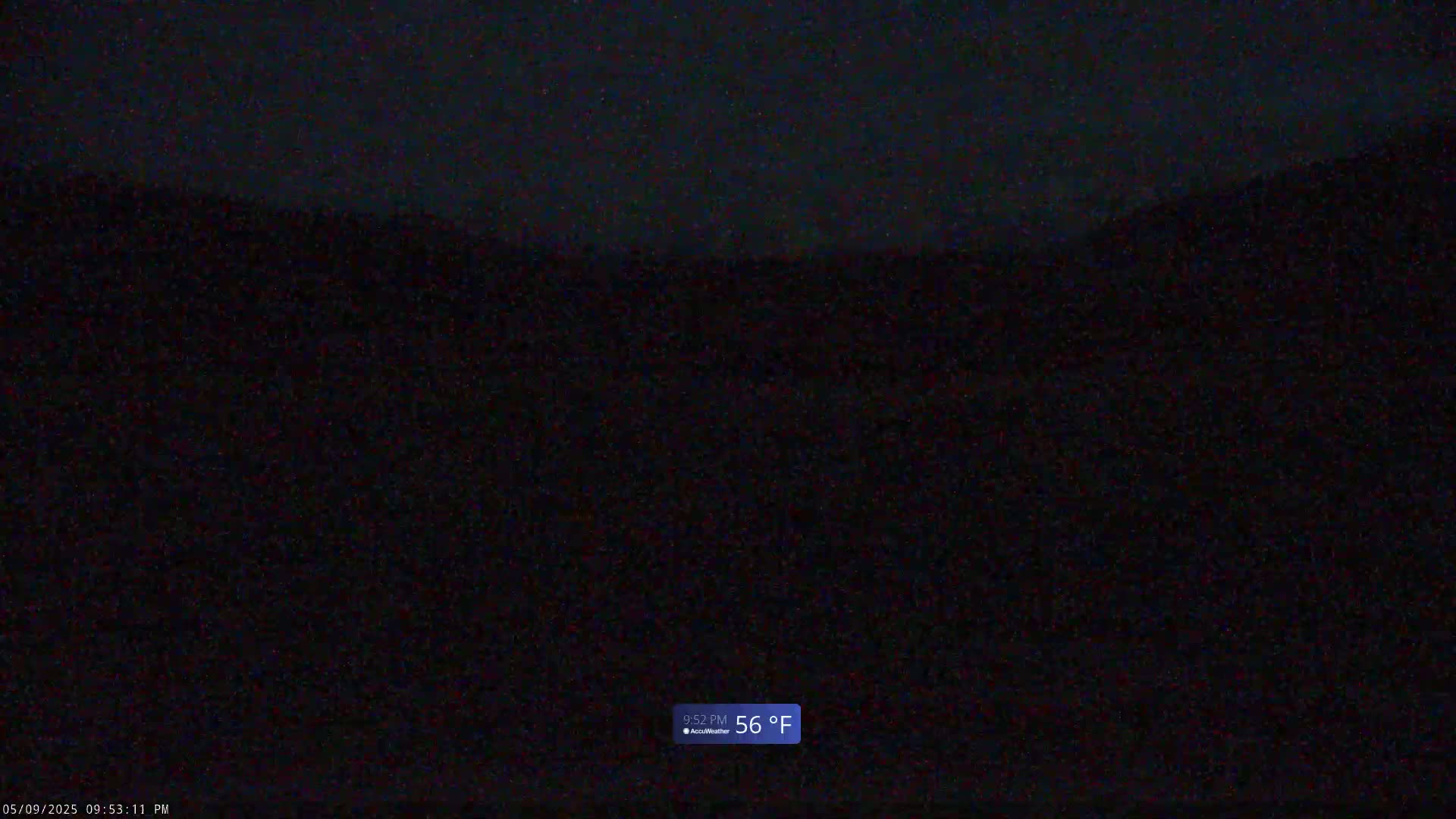 A dark, nighttime outdoor scene shows a blurry, indistinct landscape under a clear sky with a temperature of 56°F.