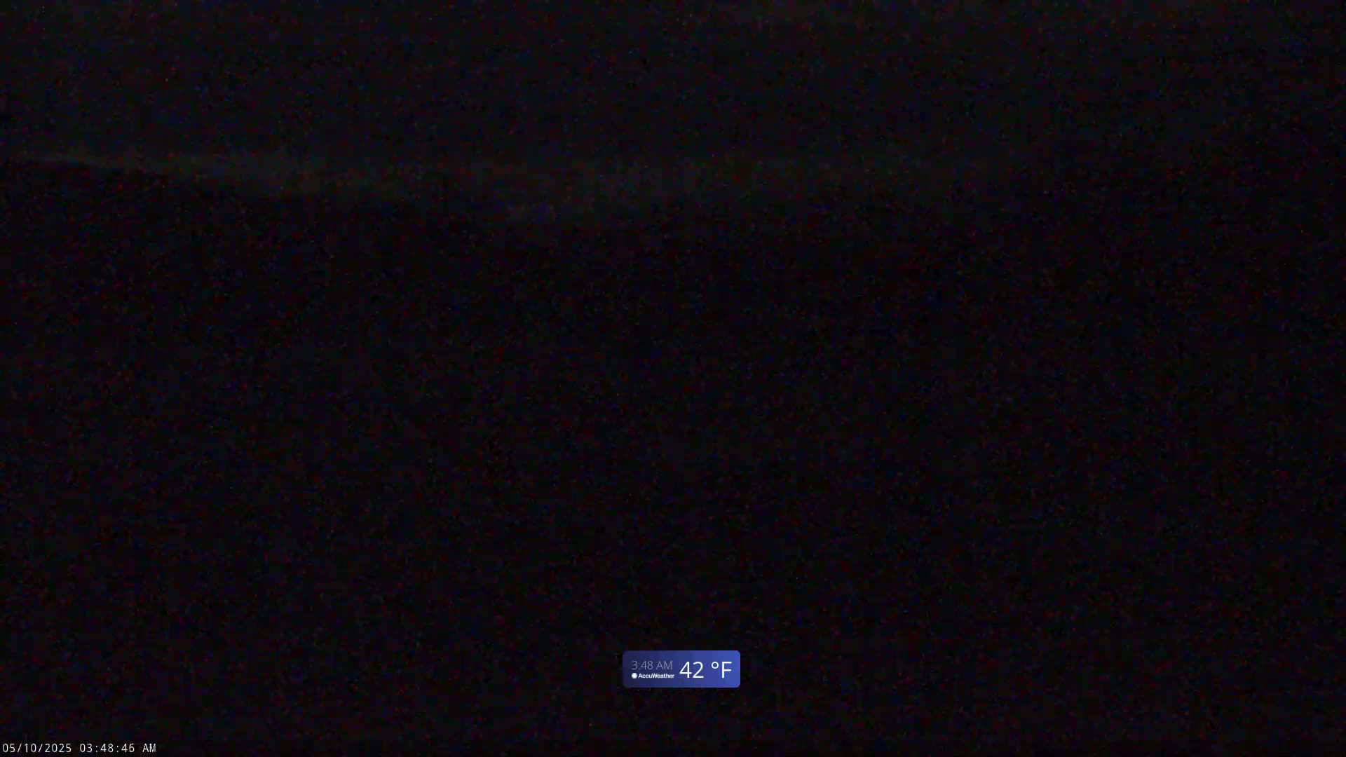 A dark, nighttime scene shows a faint, light horizon line under a mostly clear sky, with a temperature of 42°F.