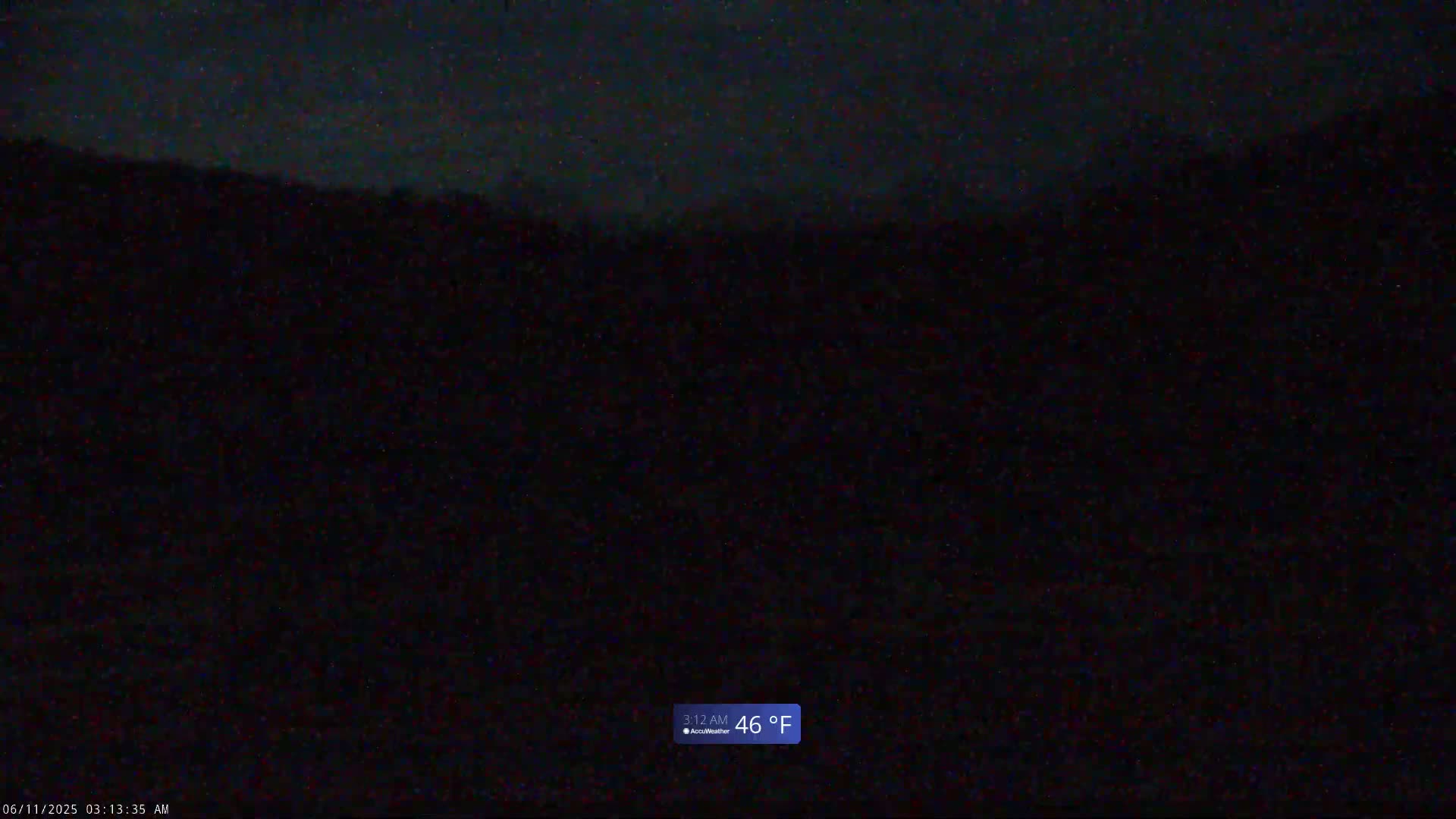 A dark, nighttime outdoor scene shows a mostly black landscape under a slightly lighter sky, with a temperature of 46°F.