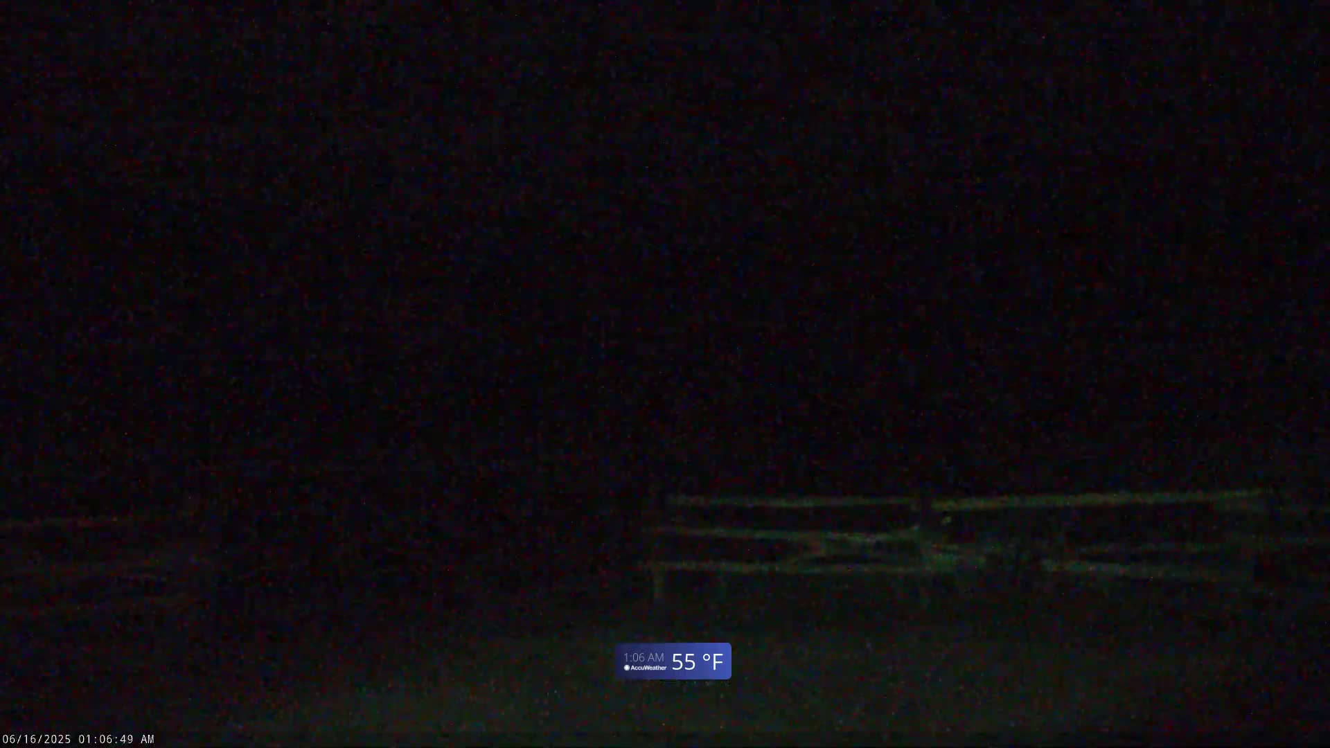 A dark, nighttime outdoor scene shows a low-lying fence in the lower portion of the image, with a temperature of 55°F.