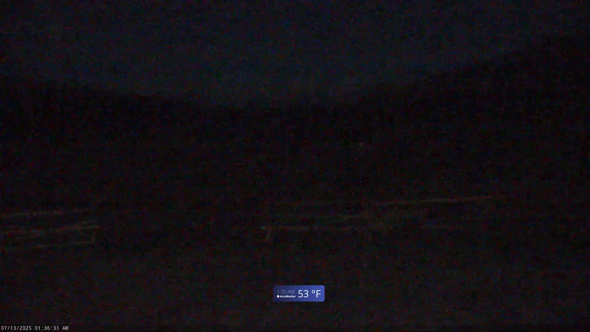 A dark, nighttime outdoor scene shows a mostly indistinct landscape under a dark sky with a temperature of 53°F.