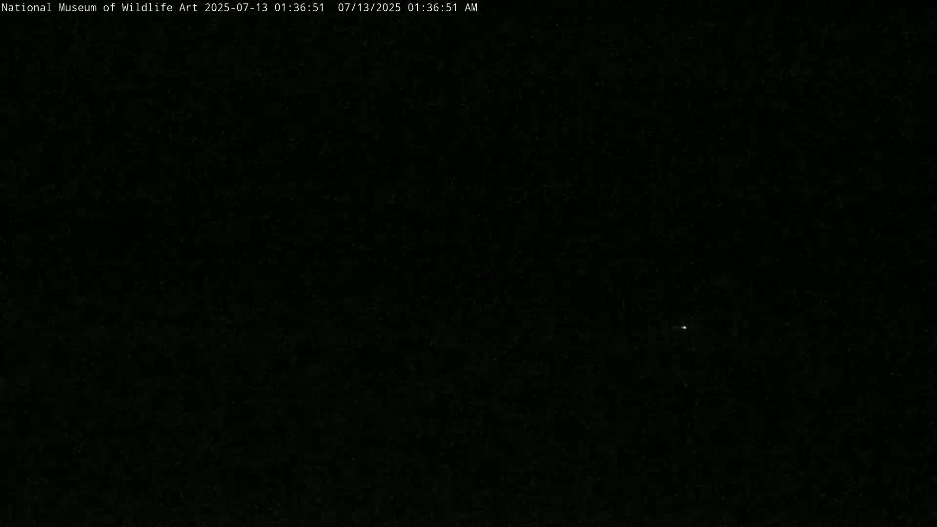 A single, faint light is visible in a dark, nighttime sky.