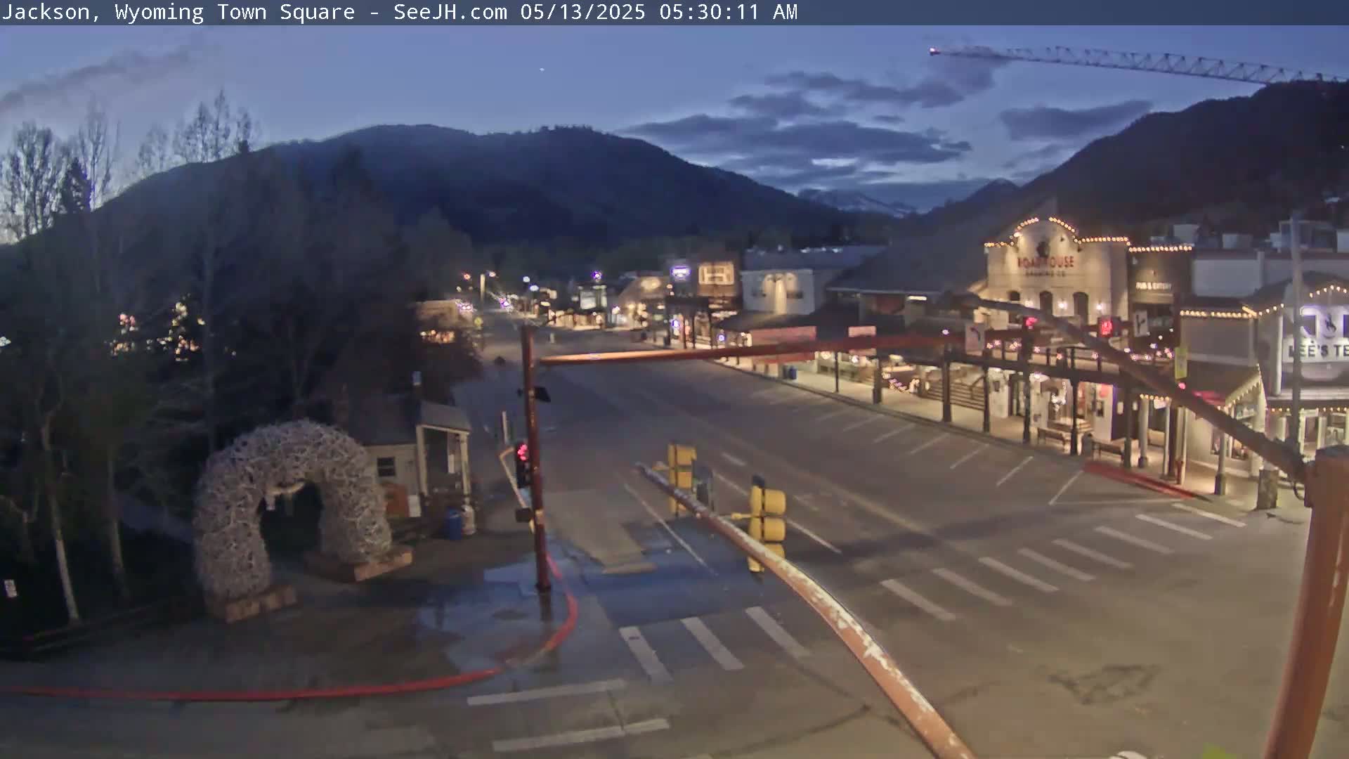 A mostly empty town square at twilight, nestled between dark mountains under a dusky sky.