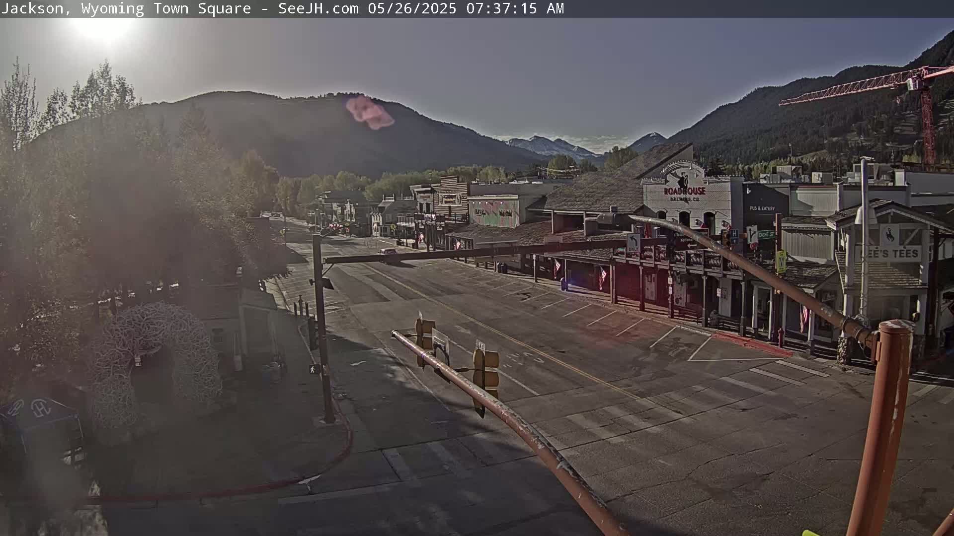 A mostly empty town square in a mountain valley on a sunny morning.