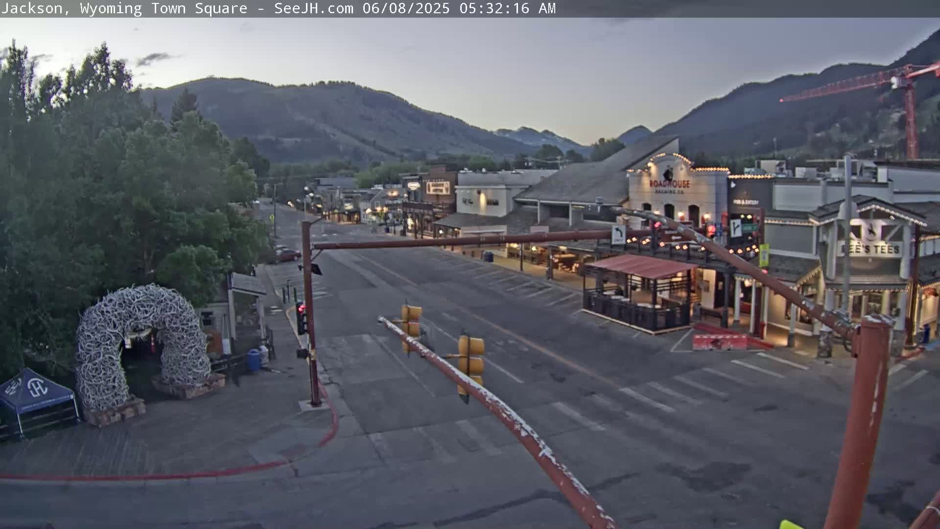 A mostly empty town square at dawn, with low light and mountains in the background.
