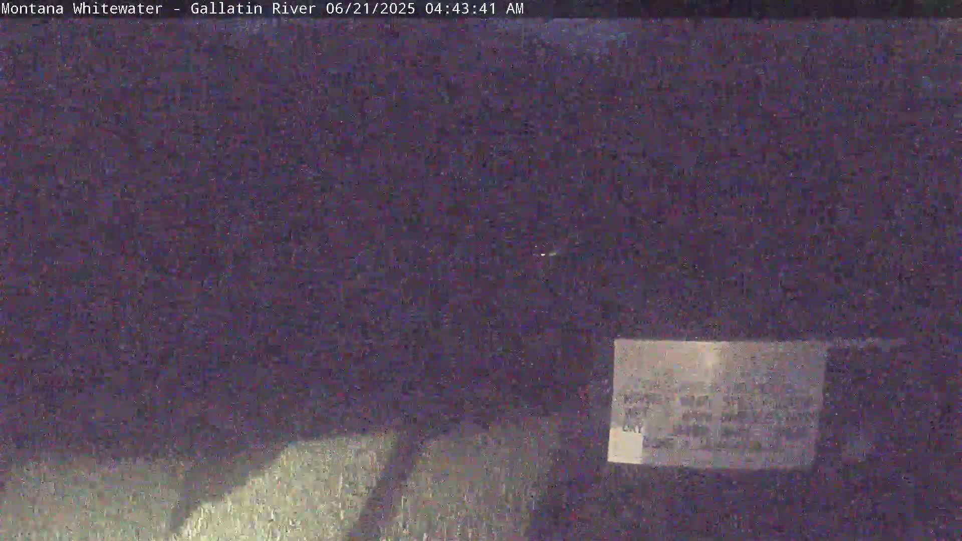 A dark, blurry nighttime image shows a mostly indistinct outdoor scene.