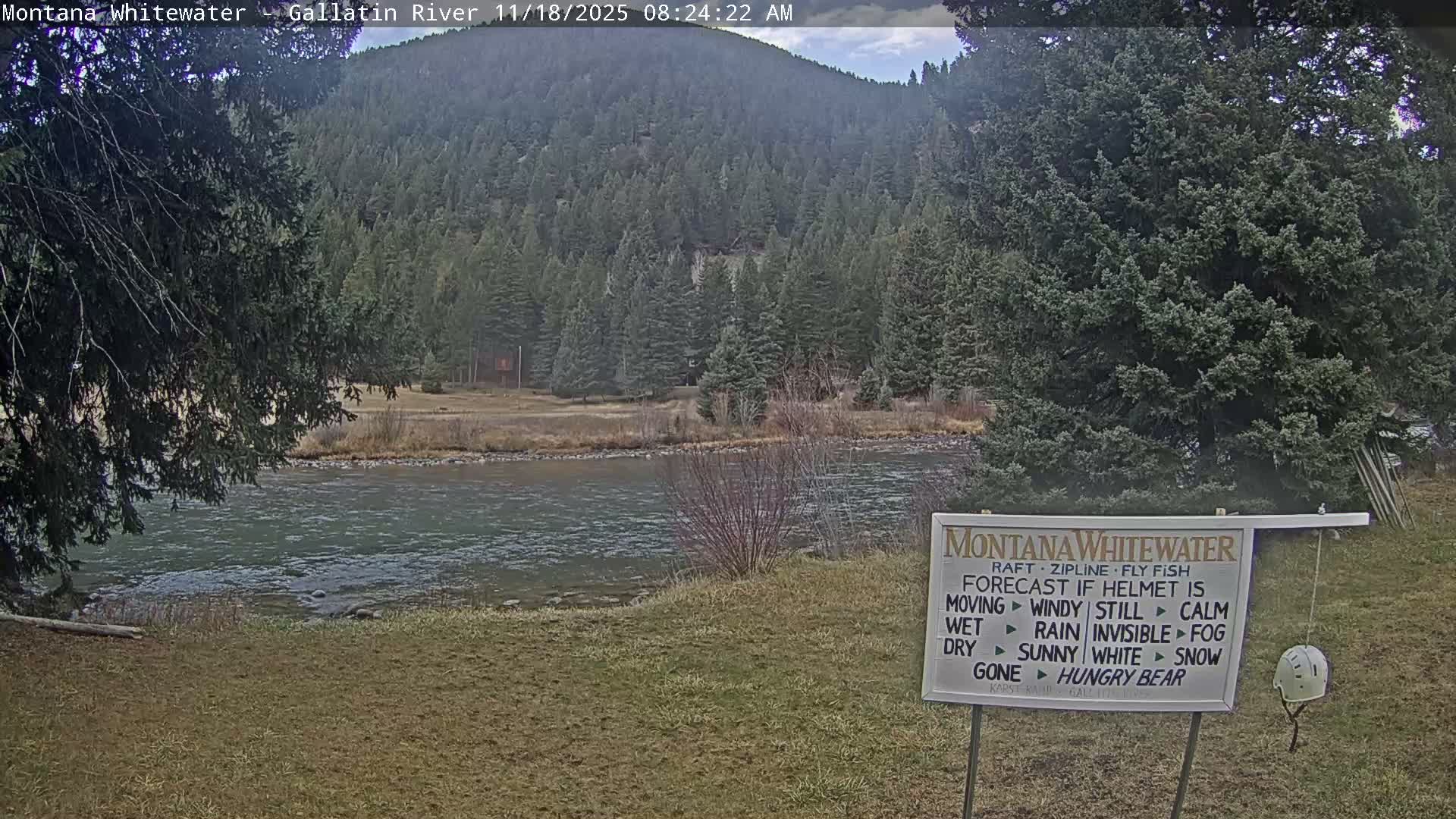 A nighttime, low-light view of a dark, possibly rural landscape with a faintly illuminated area in the middle distance.
