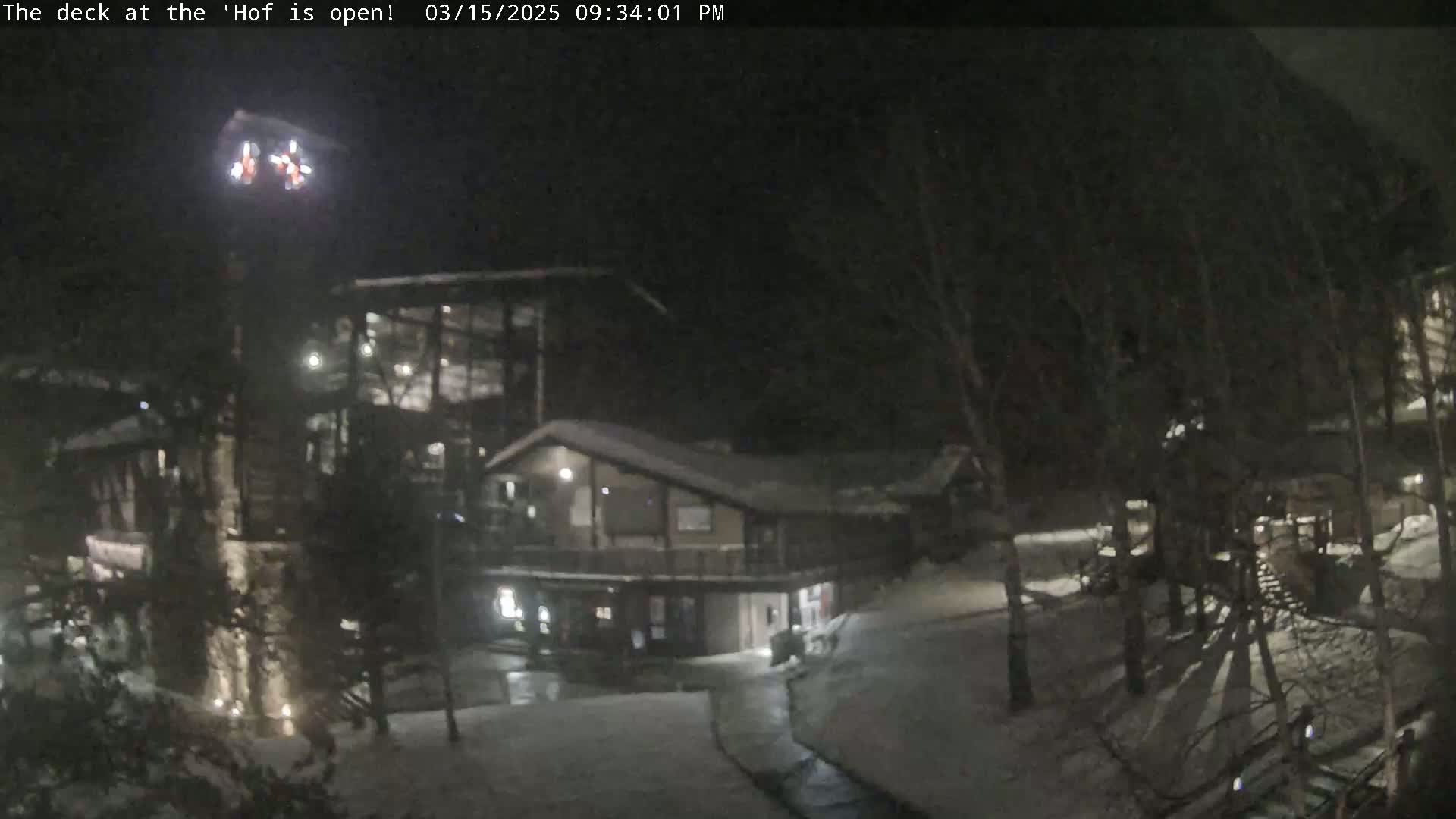 A nighttime view of a snow-covered complex of buildings, illuminated by artificial lights.