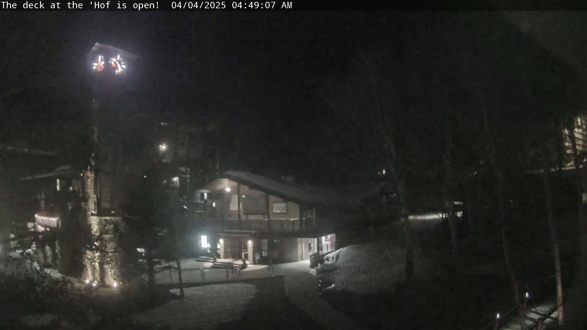 A nighttime view of a snow-covered building complex with some outdoor lighting.