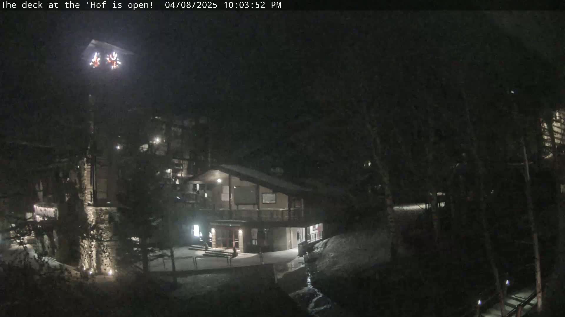 A nighttime view of a snow-covered building complex partially illuminated with outdoor lighting.