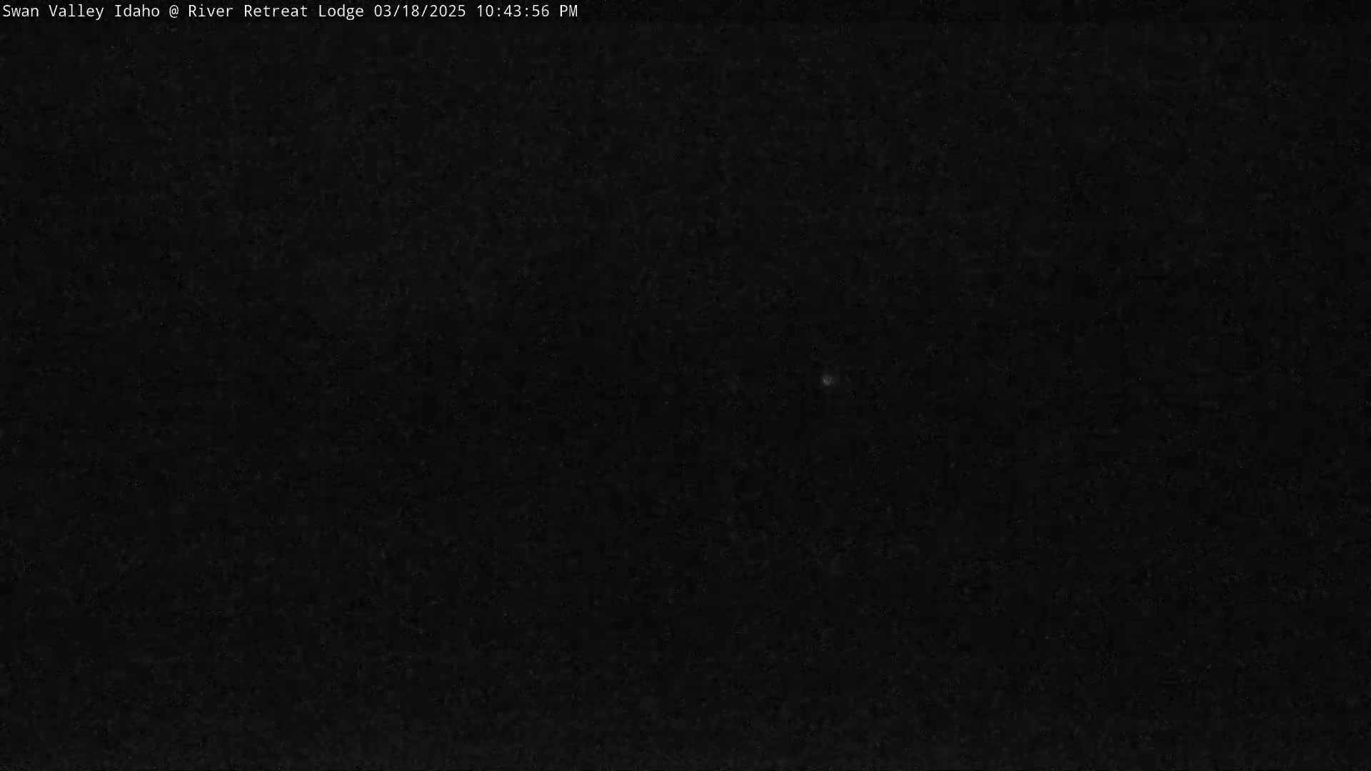 A dark, nighttime outdoor scene shows a mostly clear sky with a few faint lights.